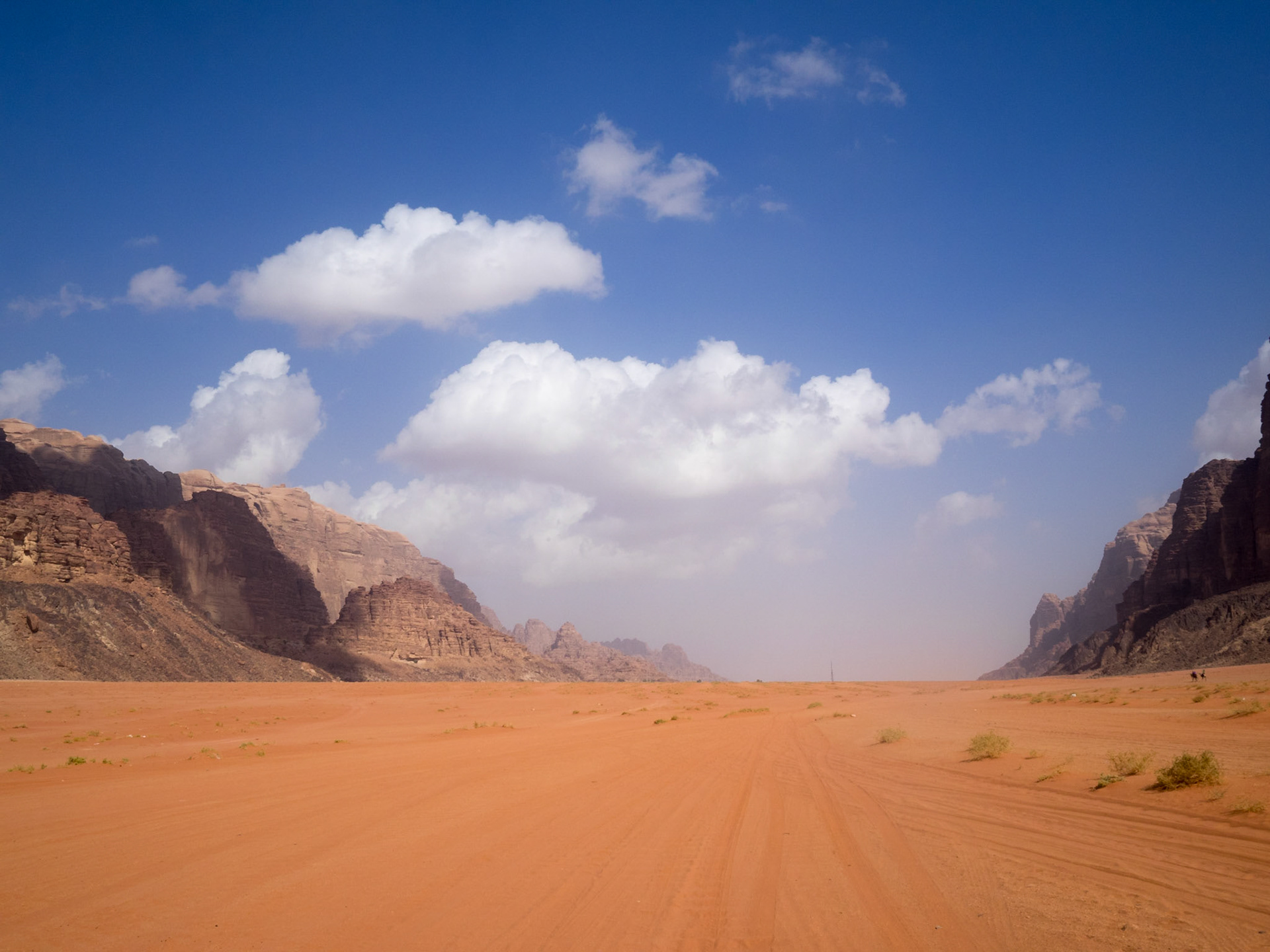 Flat red sand landscape between the rocky mountains of Wadi Run