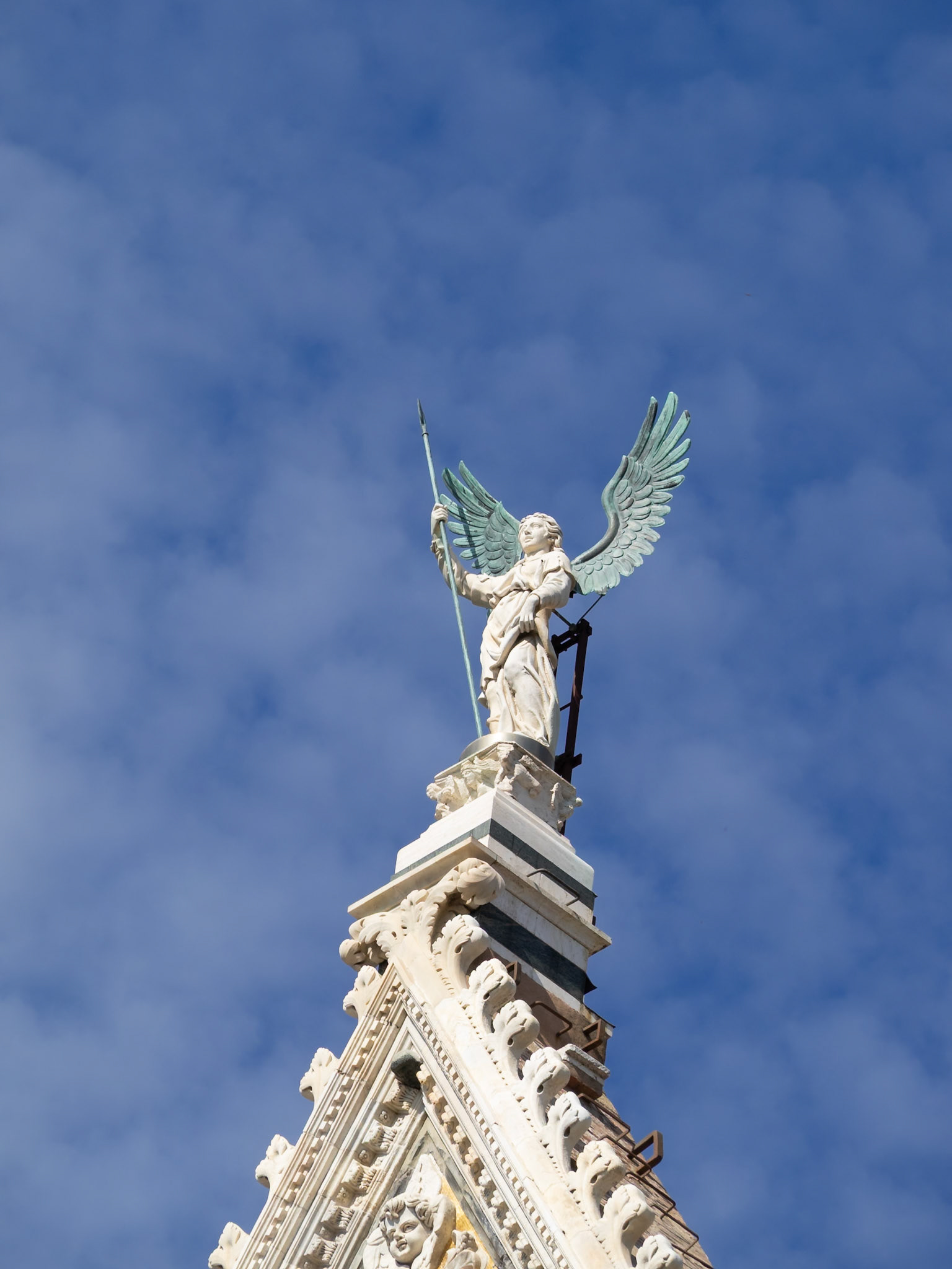 Angel statue atop the facade on Siena Cathedral