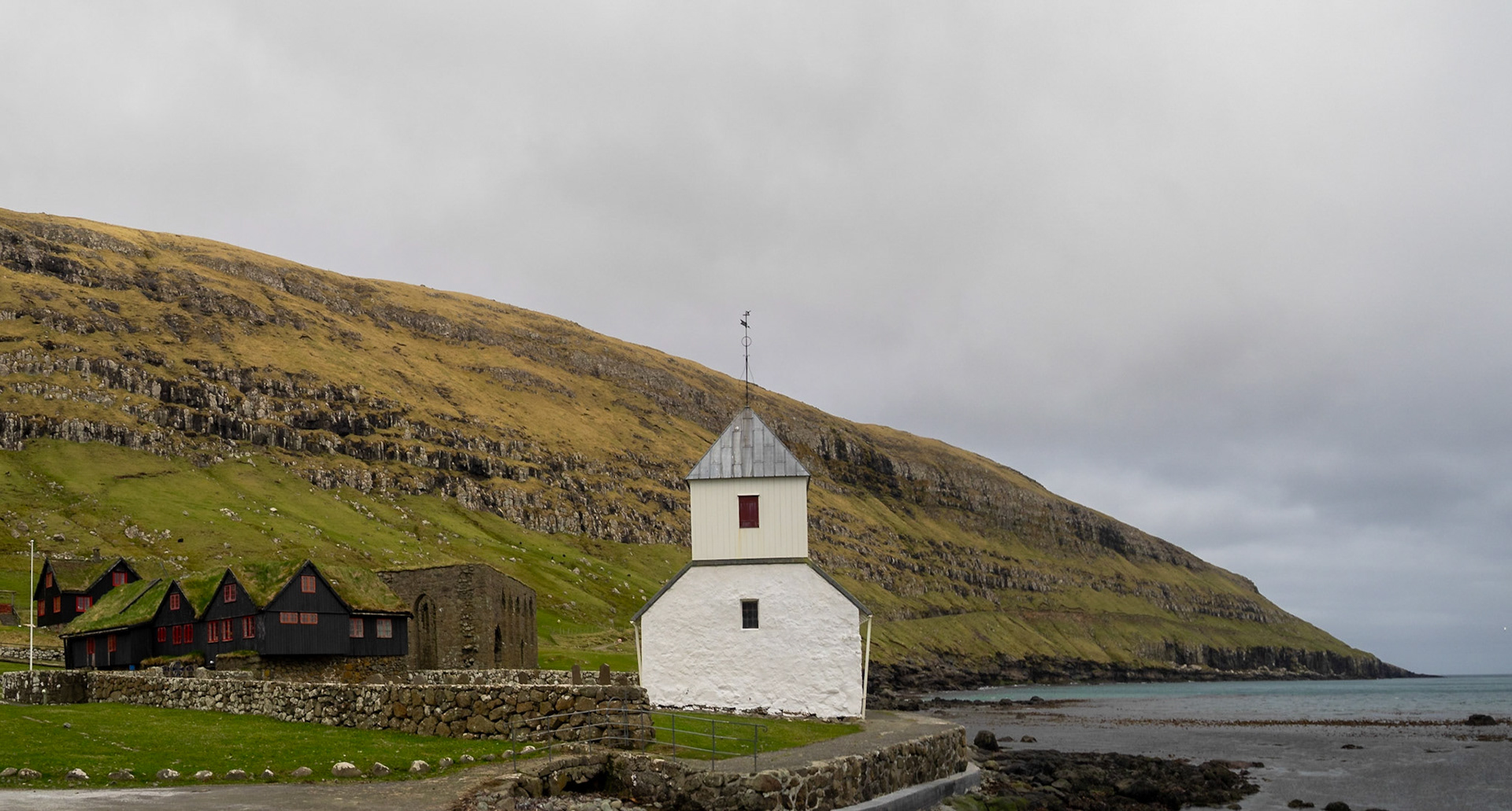 Ólavskirkjan church by Roykstovan farmhouse, and Magnus Cathedral ruins in background, Kirkjubøur
