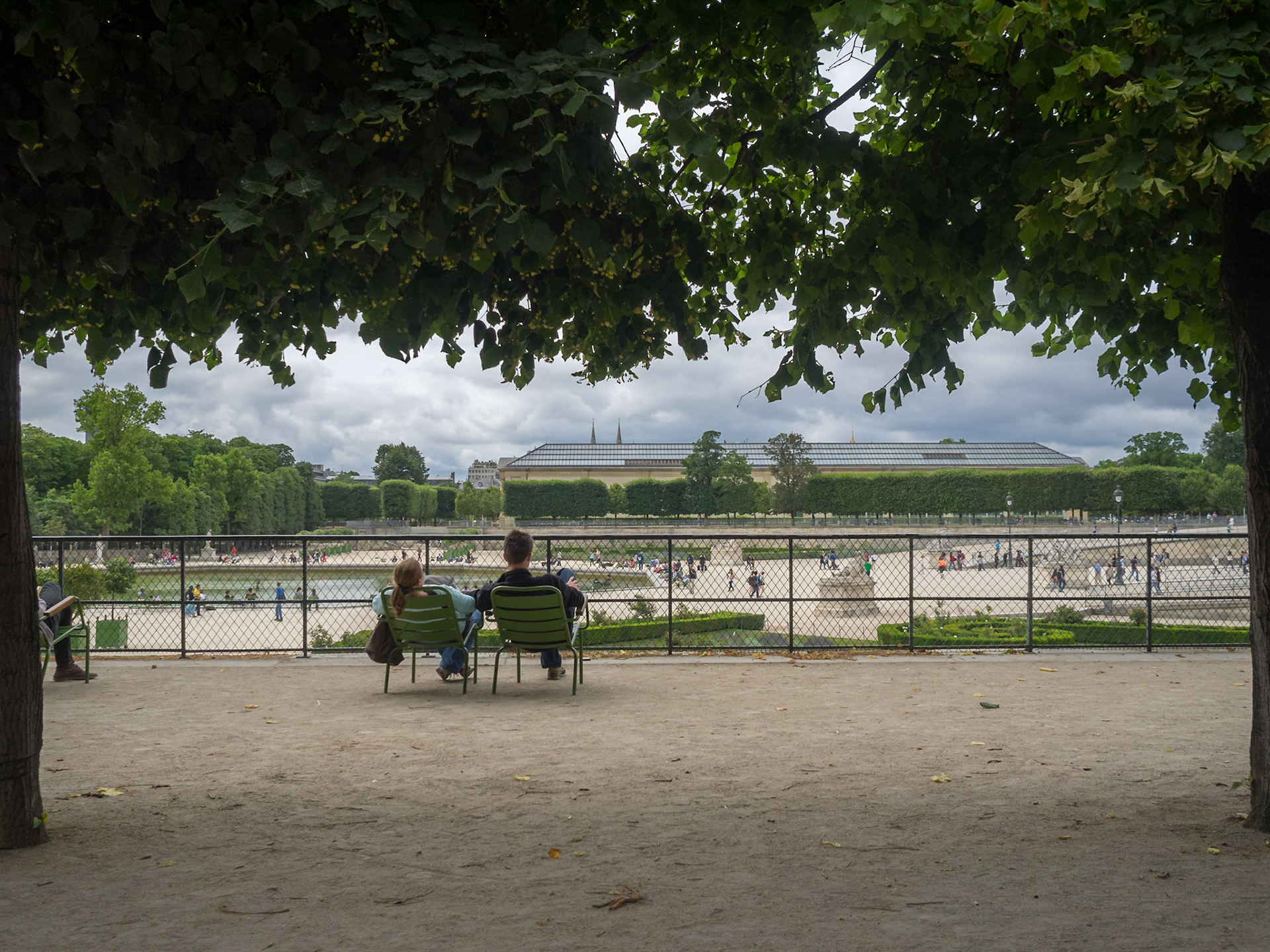 People wresting in the Tuilerie garden framed by the trees
