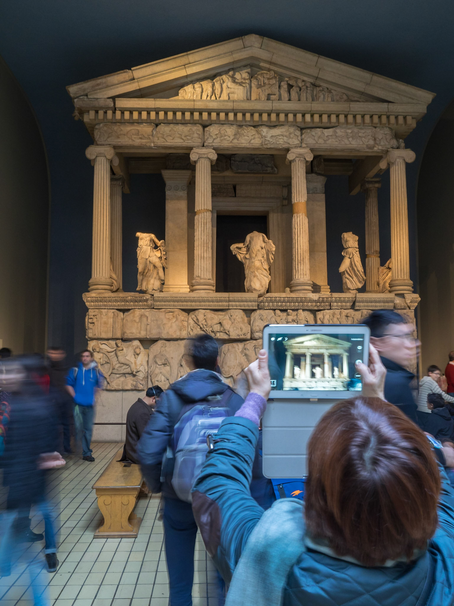 Visitor taking a picture of a Greek temple with a tablet at the British Museum