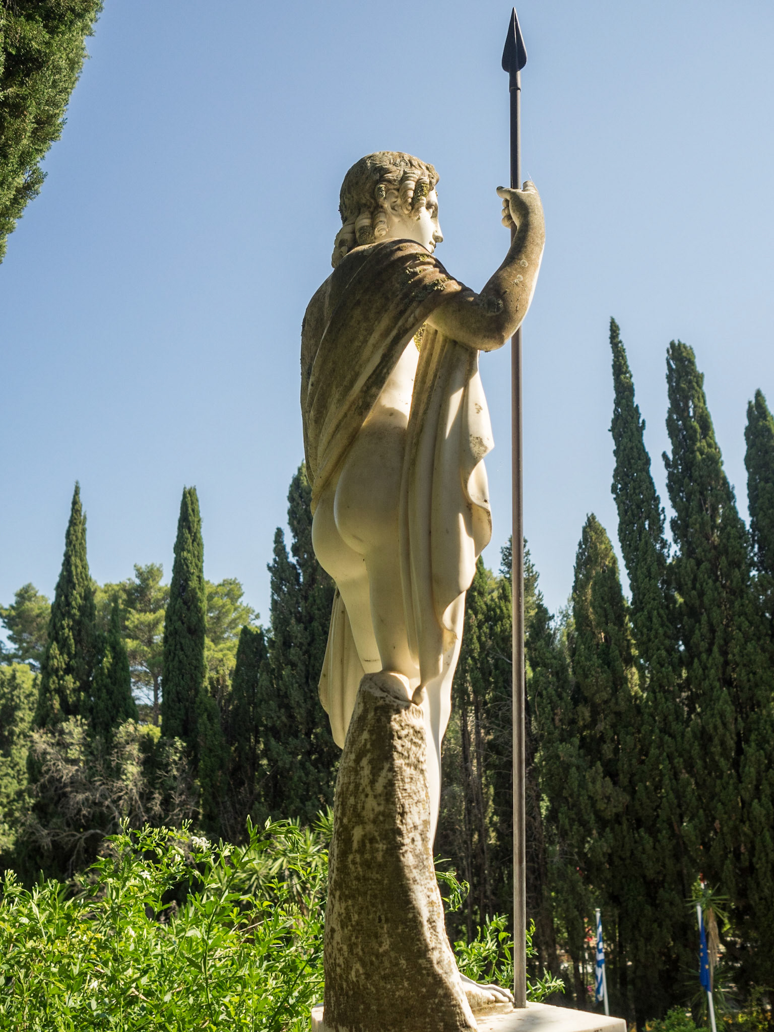 Classical statue and cypresses trees in Achillion Palace garden