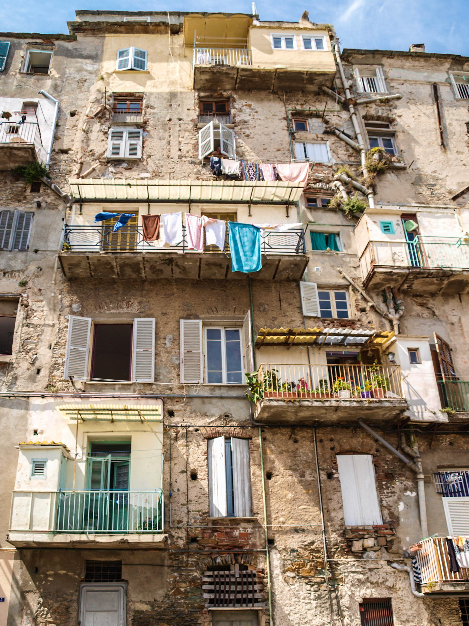 Old building facade, with balconies and windows with drying clothes