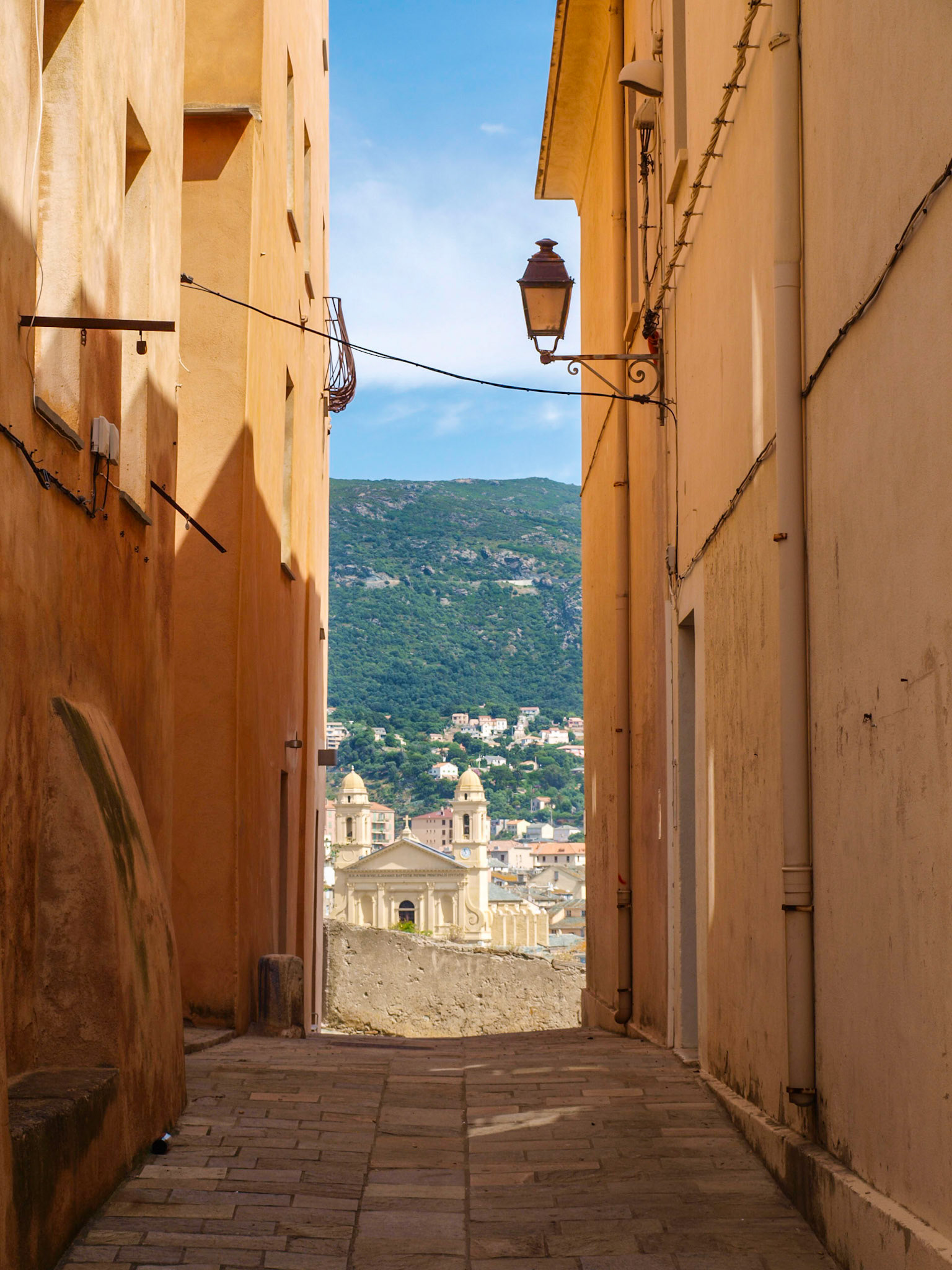 Bastia street with St John Baptist church towers at the end