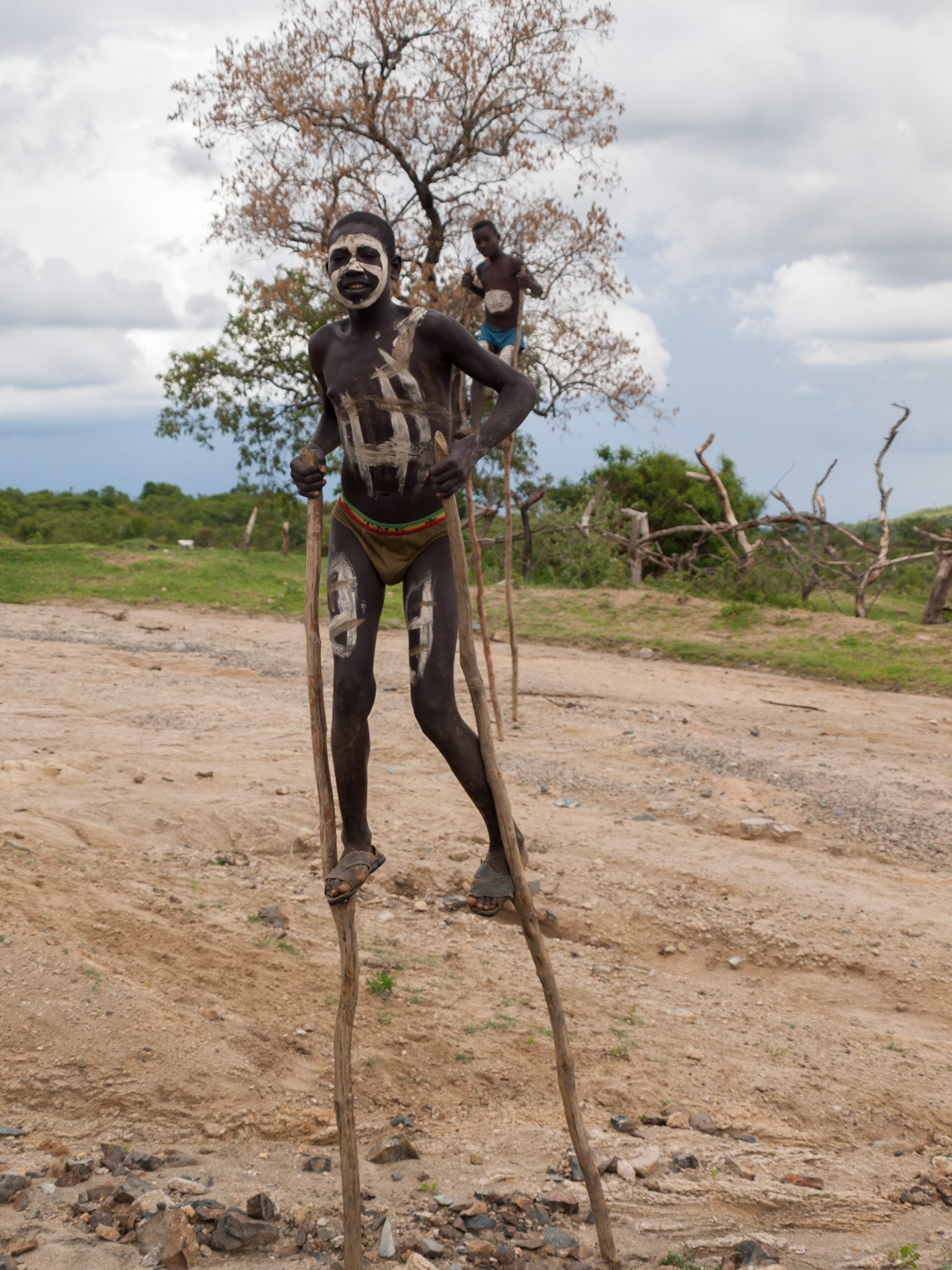 Teenage Banna boys in stilts with painted bodies