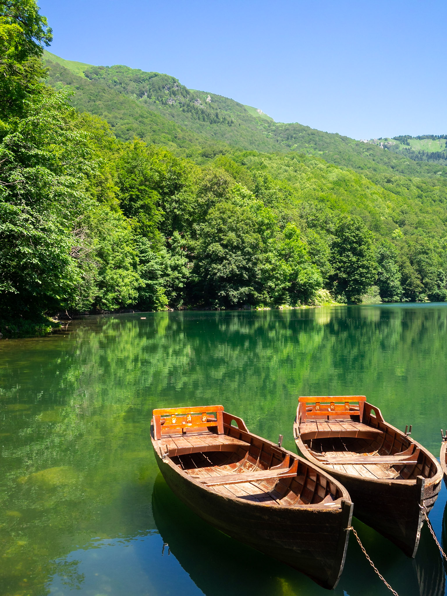 Two boats in Lake Biograd with  the reflection the surrounding forest trees in the water