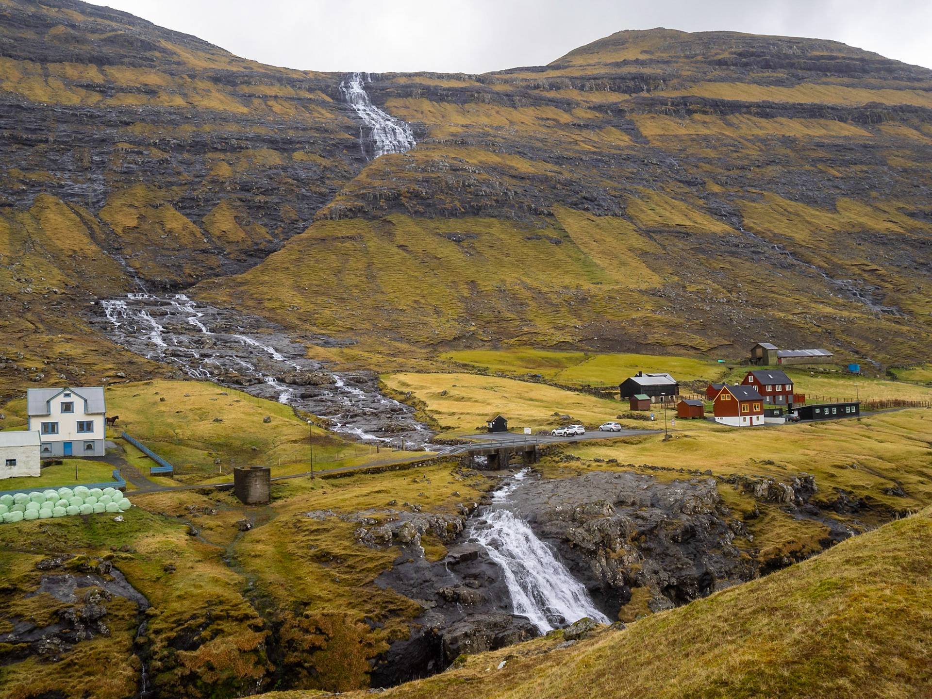 A waterfall descends the mountains in Saksun