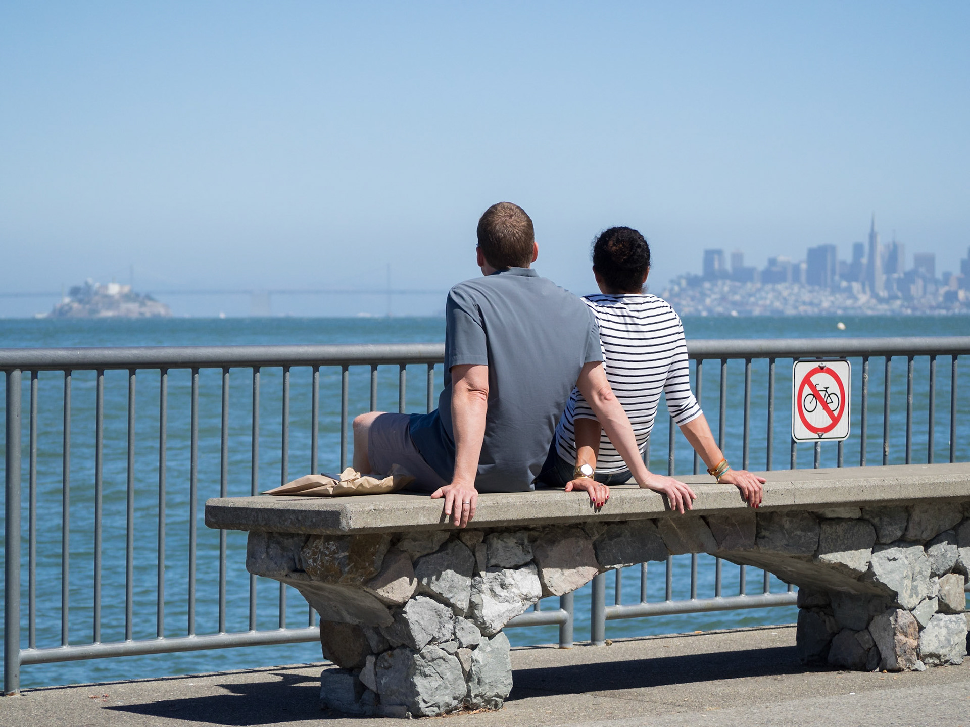 A couple admires San Francisco skyline from Sausalito seafront