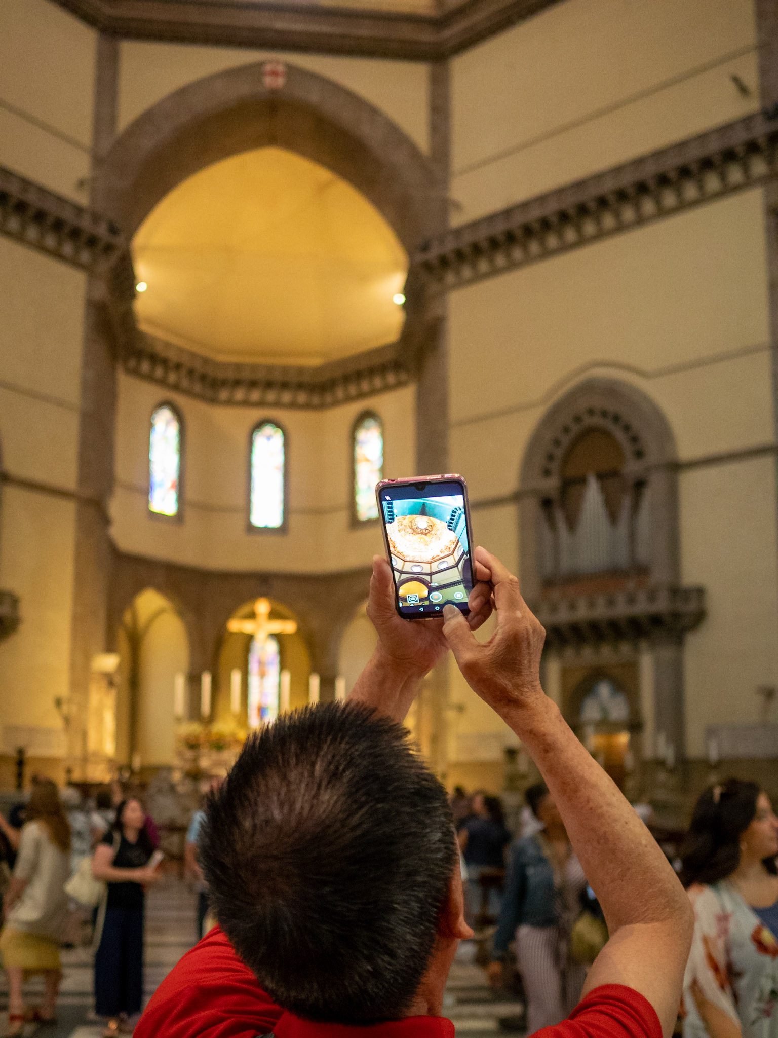 A tourists takes a picture of the florence Duomo dome interior with the mobile phone