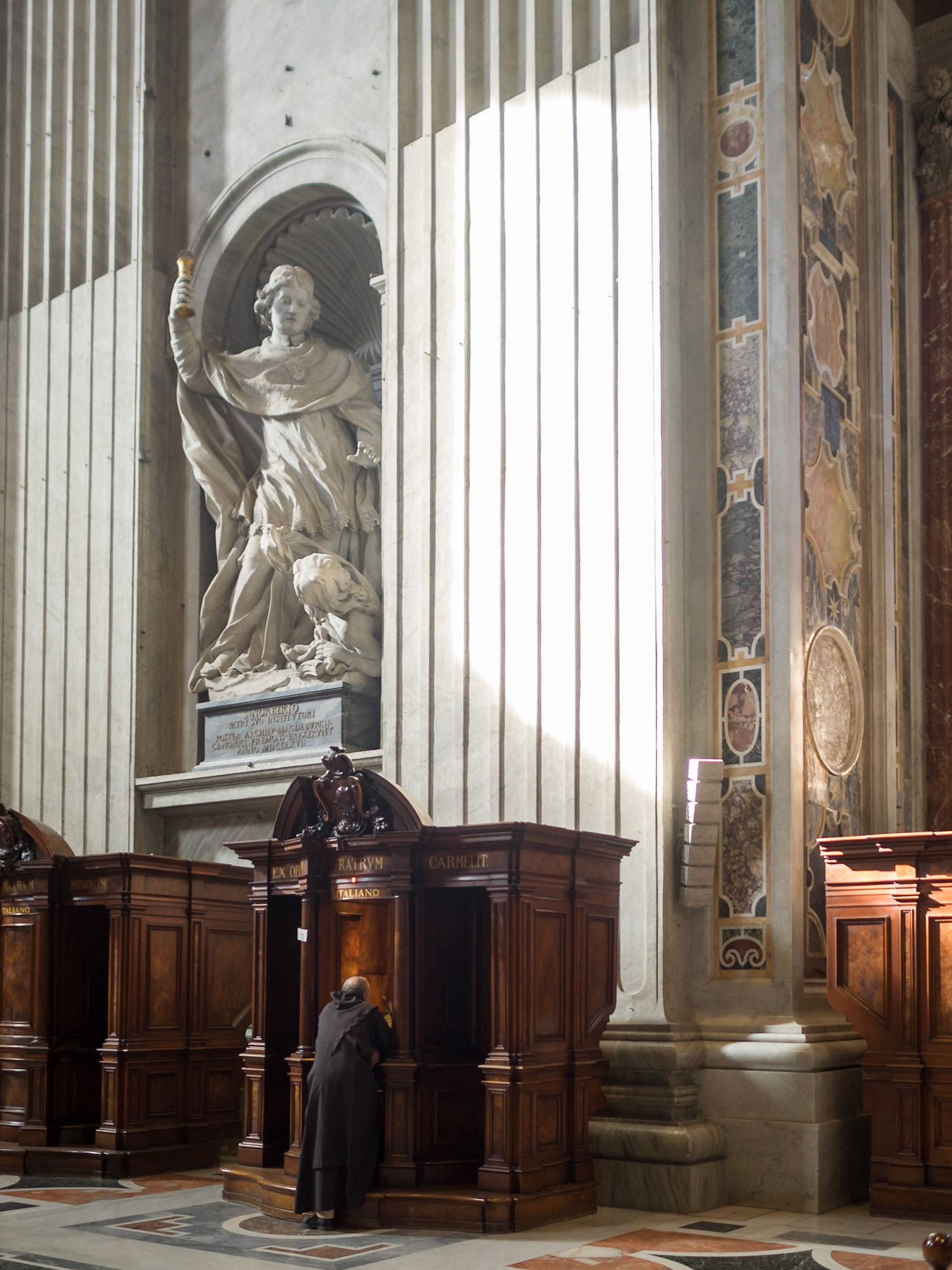 A priest by a confessional inside St. Peter's Basilica