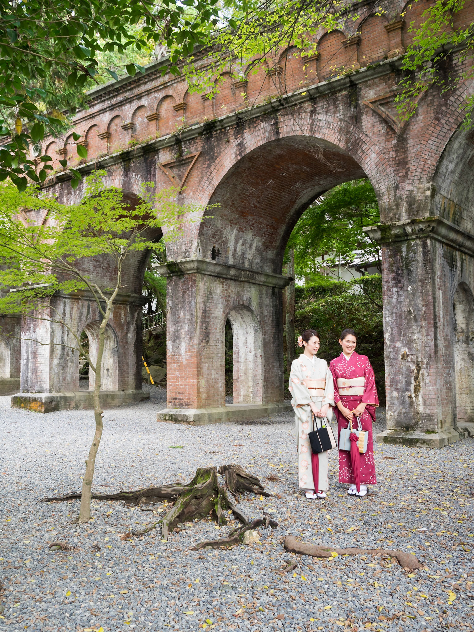 Two women in traditional Japanese costumes by the Nanzen-ji temple aqueduct