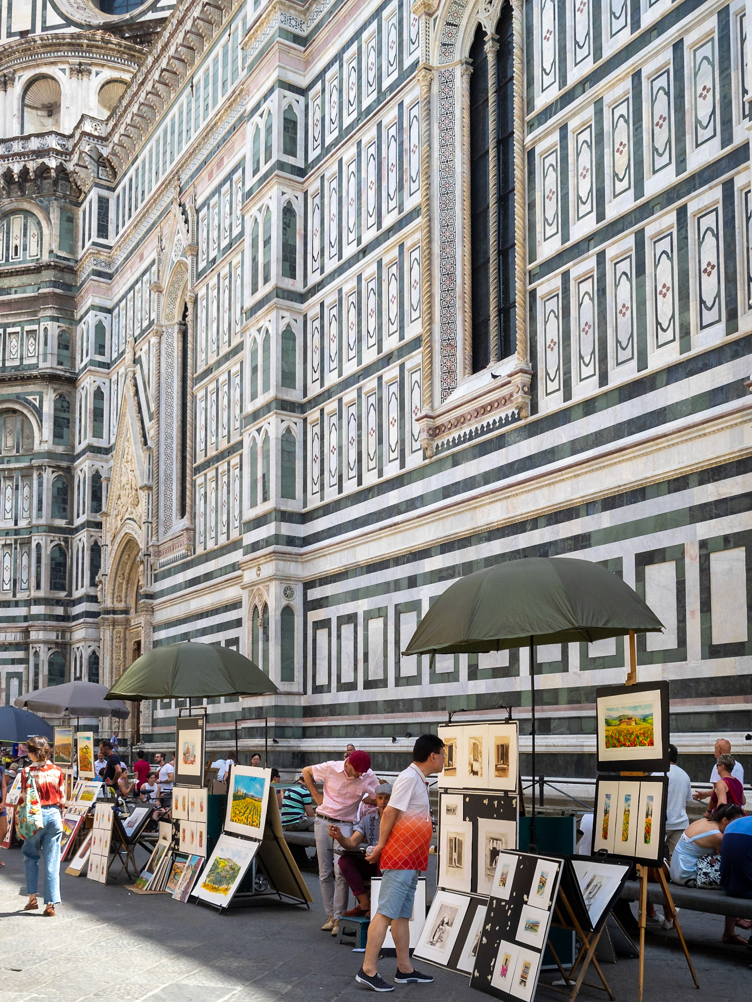 Street artists draw tourist portraits by Florence Duomo