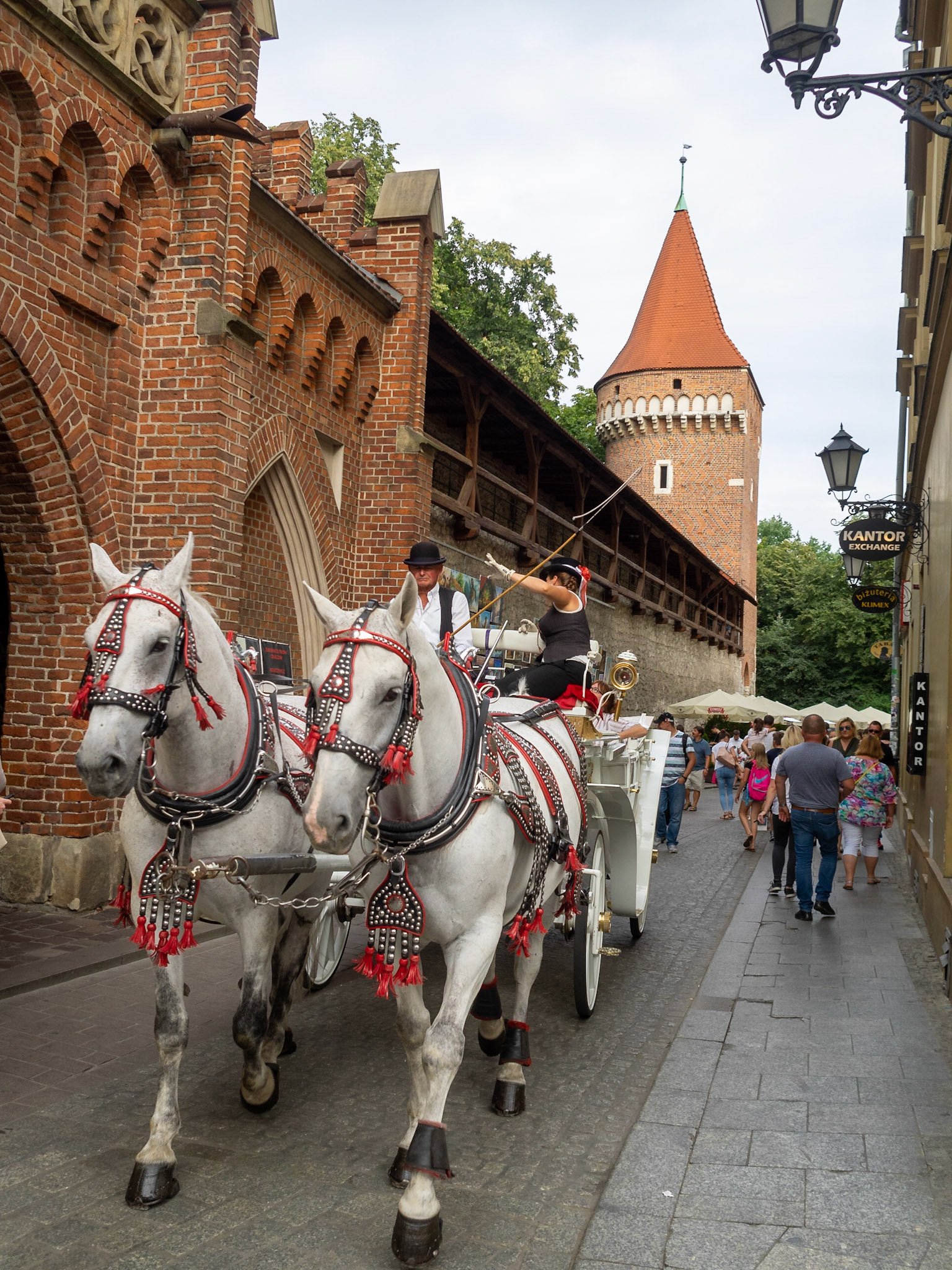 A horse chariot passing on the street by Krakow city wall