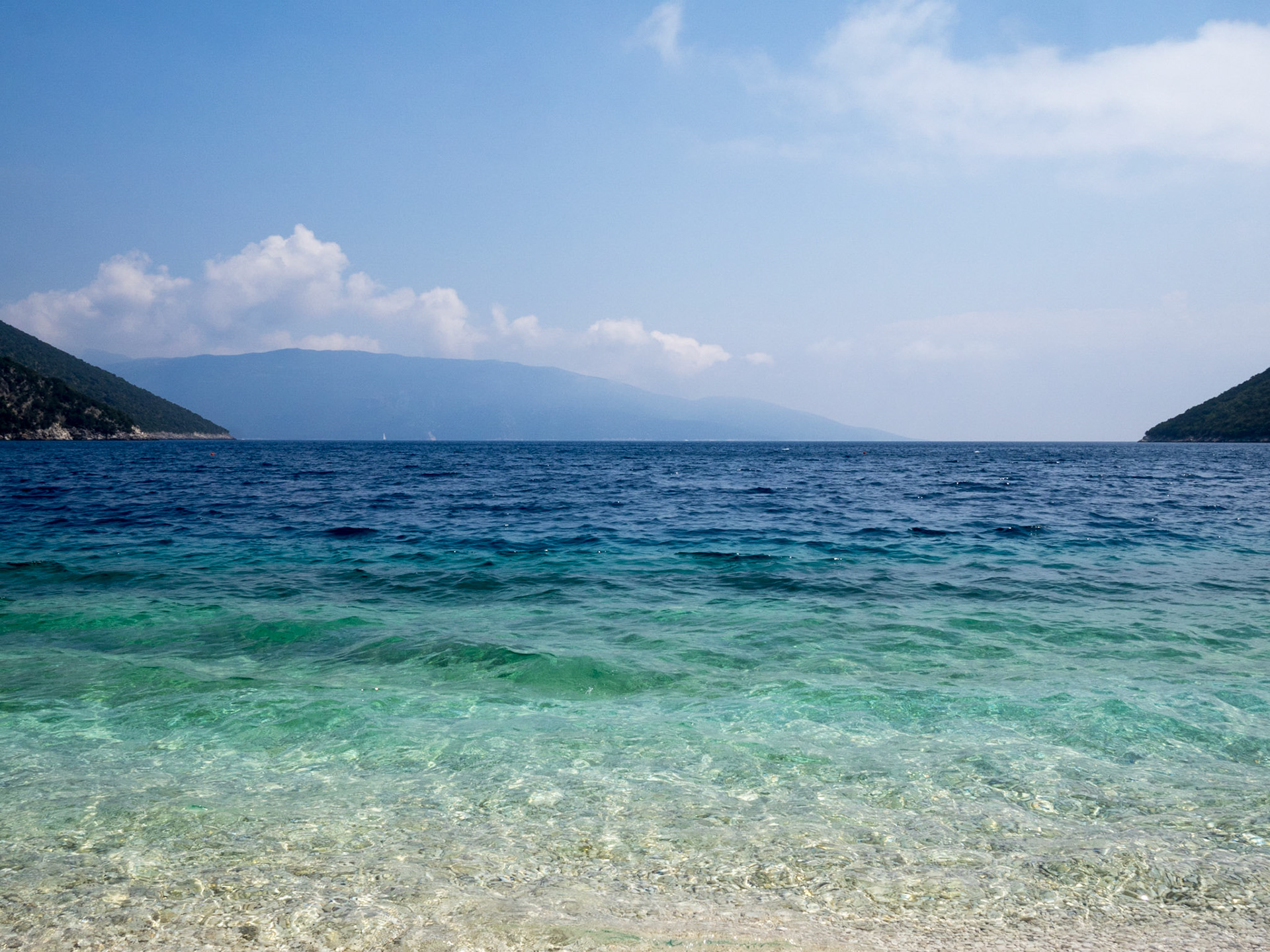 Antisamos beach turquoise waters and the mountains in the horizon