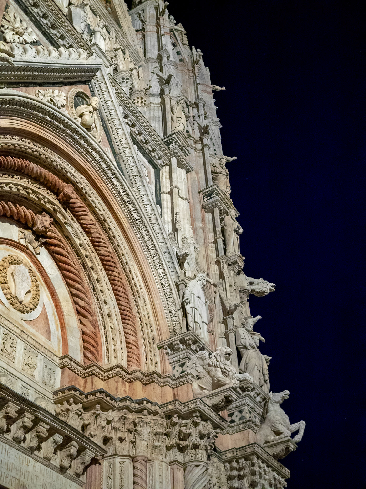 Looking up to the sone carvings covering the right corner of Siena Cathedral facade