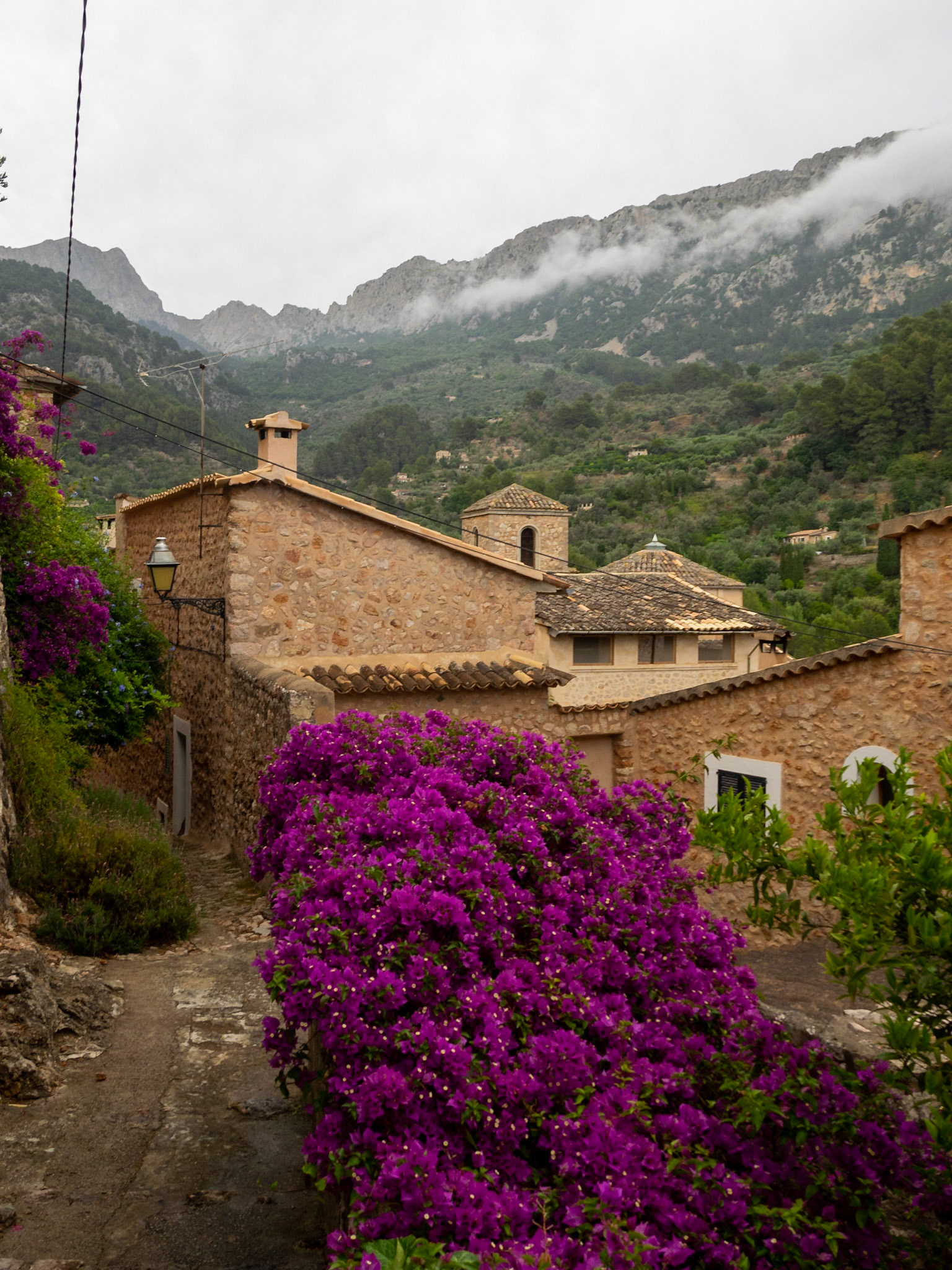 Cobbled streets and stone houses below Tramuntana mountains in Fornalutx