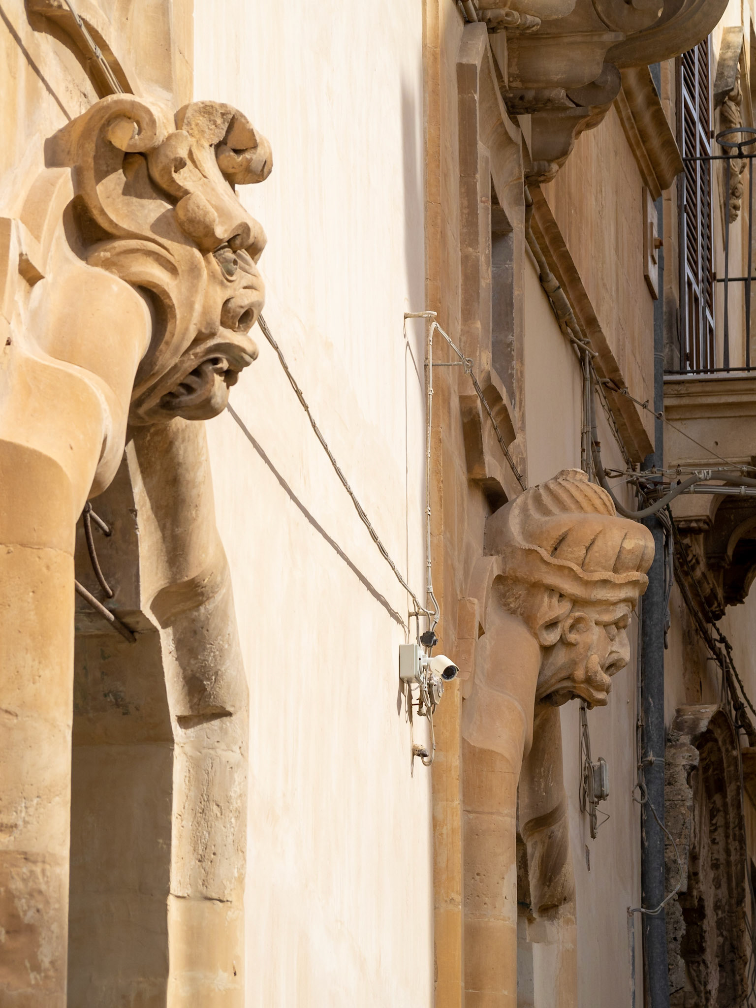 Door decorations with grotesque faces of the Baroque Palazzo Beneventano, Scicli