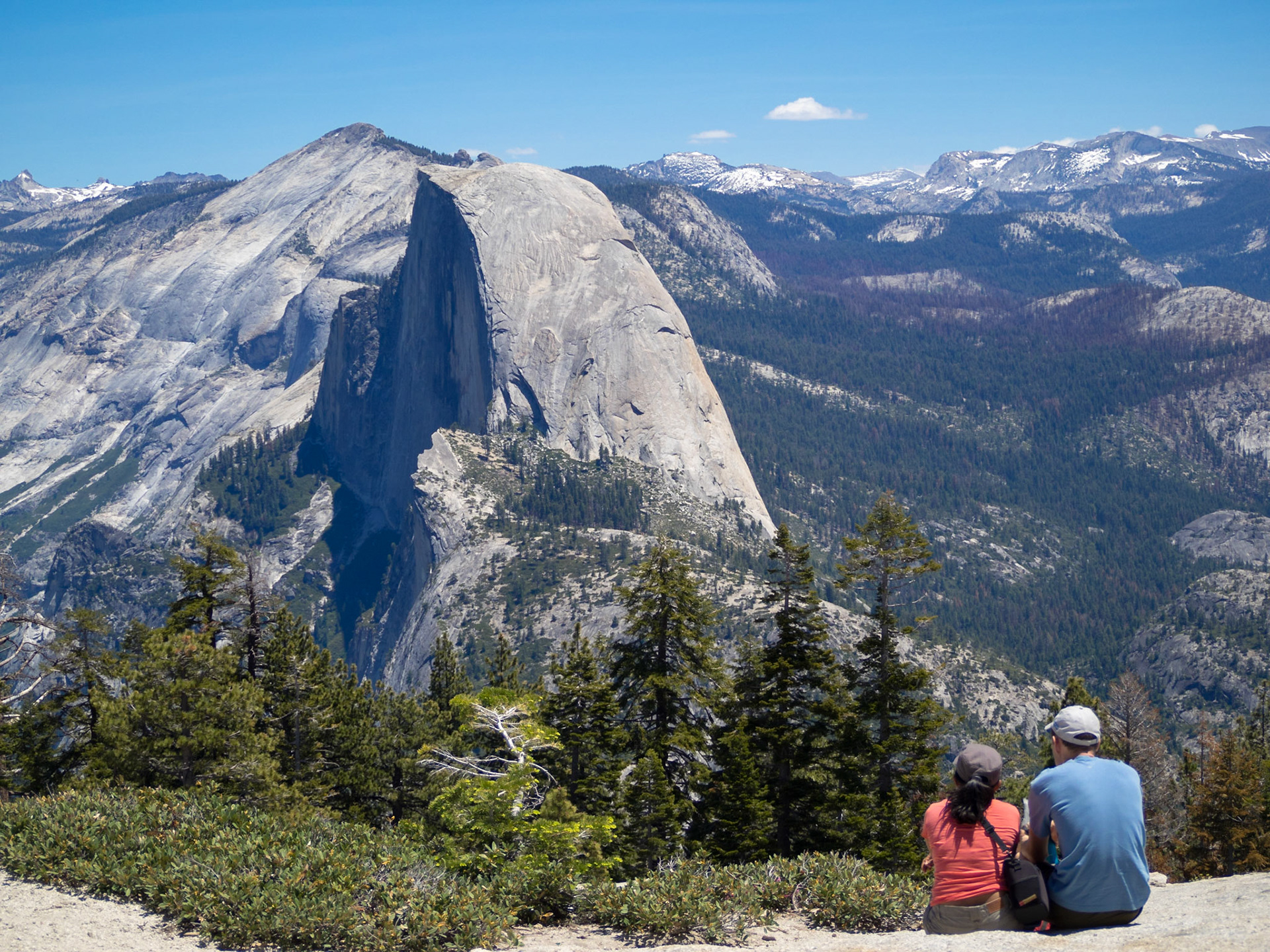 A couple looks over to Half Dome from Sentinel Dome Trail