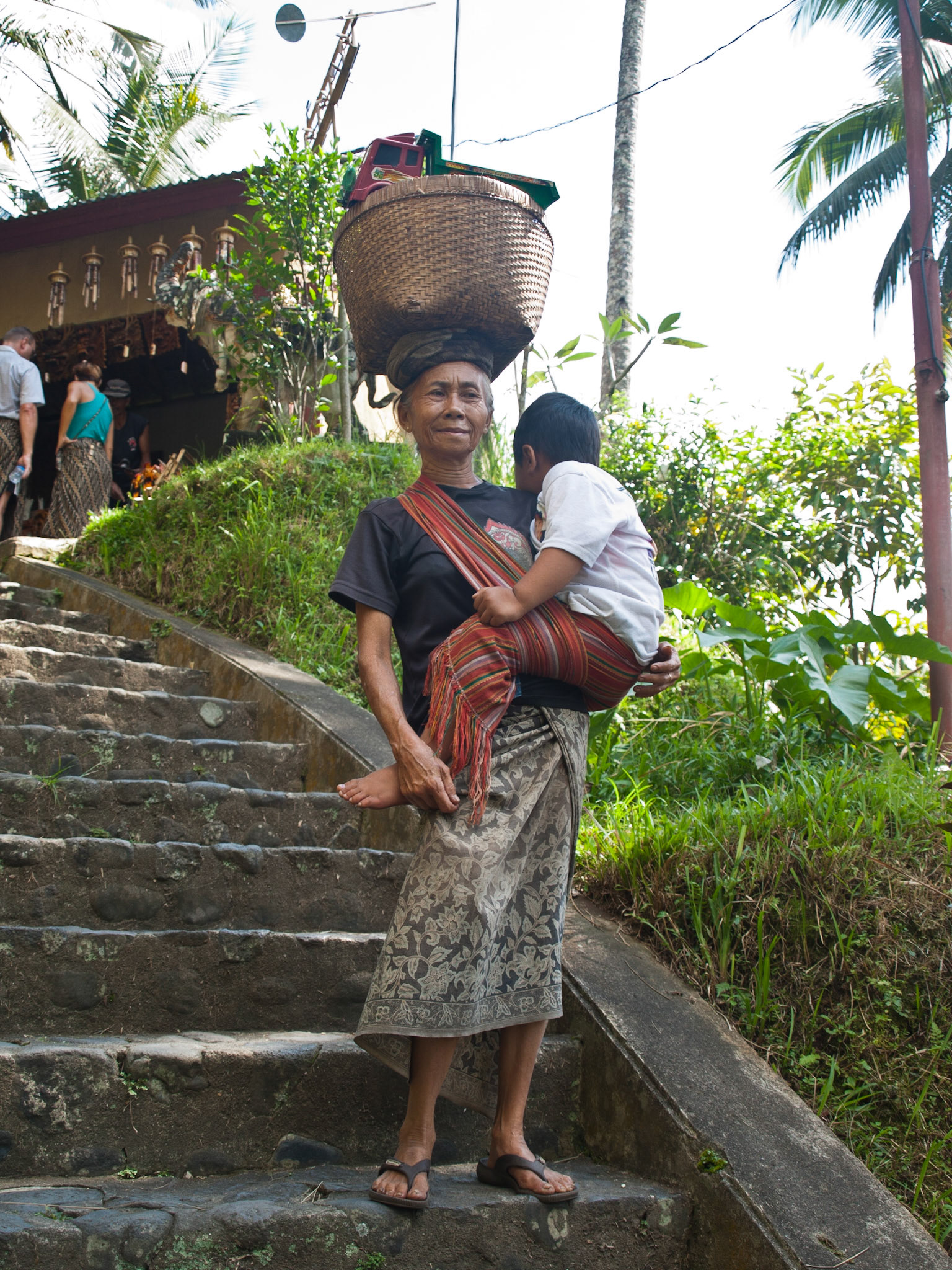 Balinese woman carrying child