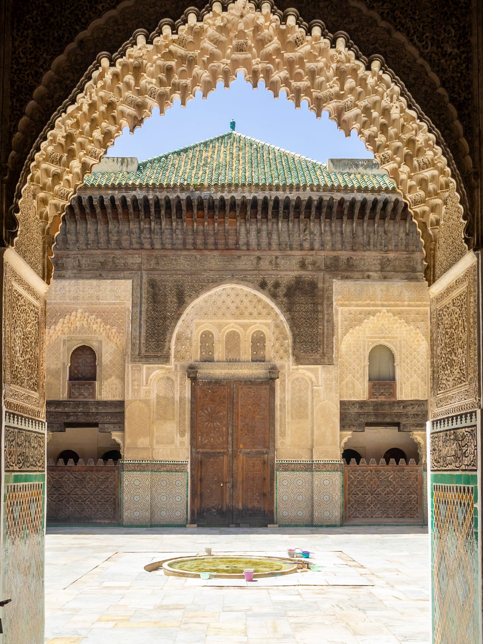 Bou Inania Madrasa courtyard seen across an arch muqarnas, Fez, Morocco