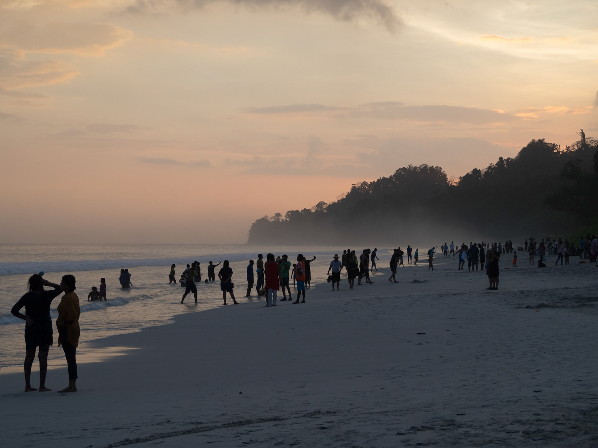 People silhouettes at sunset in Radhanagar beach, Havelock