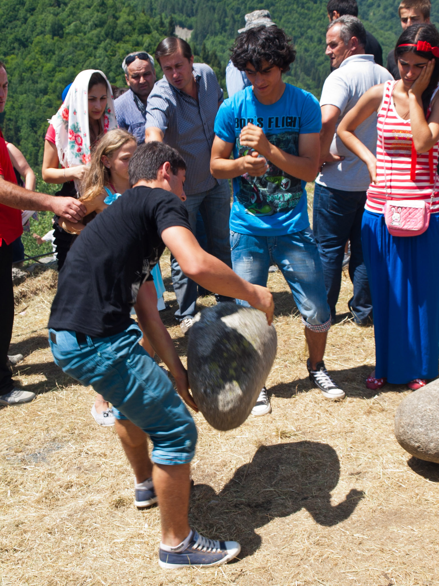 Lifting round rocks in Svaneti festivities of Lamaria Church