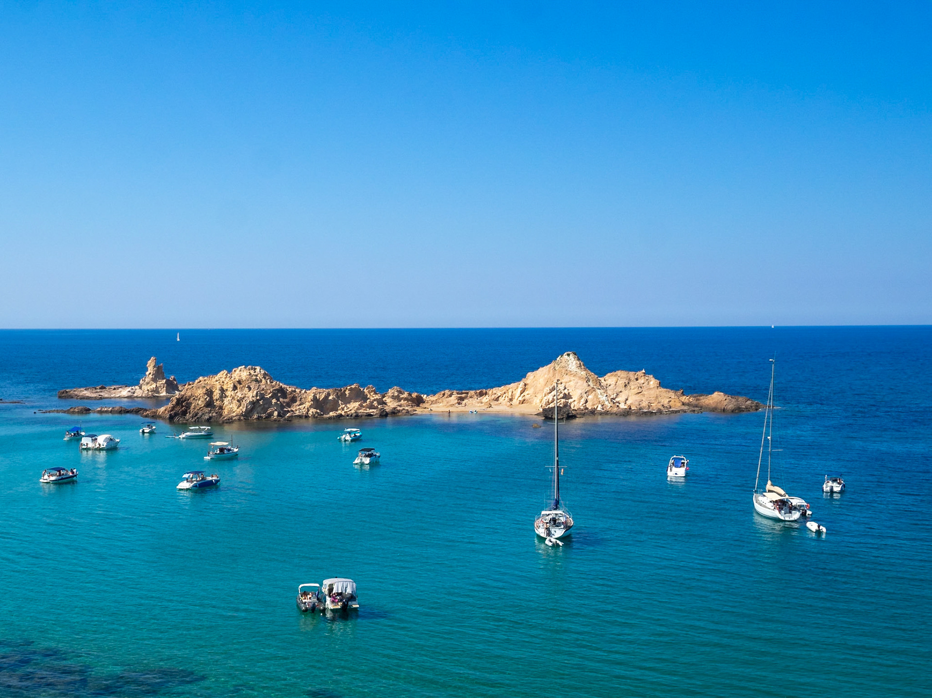 Sailboats in the turquoise sea of Cala Pregonda, Menorca