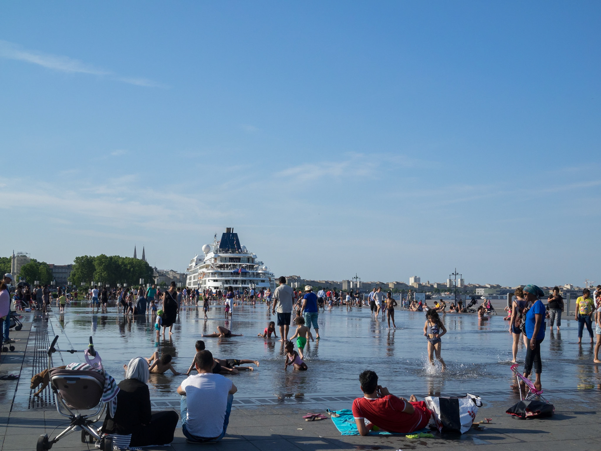 People playing and resting by Le miroir d'eau