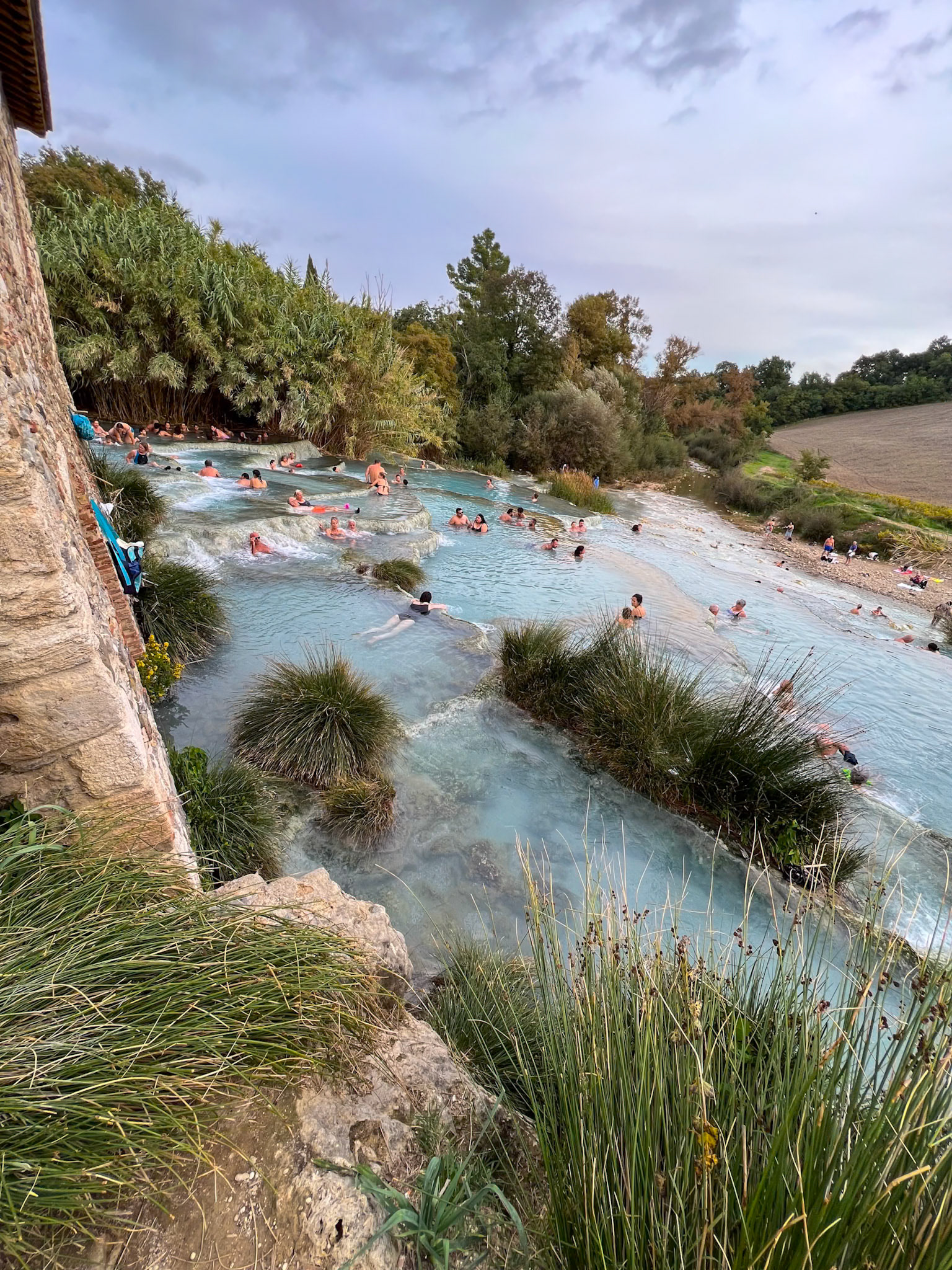 Bathers at the Cascate del Mulino hot spring in Tuscany