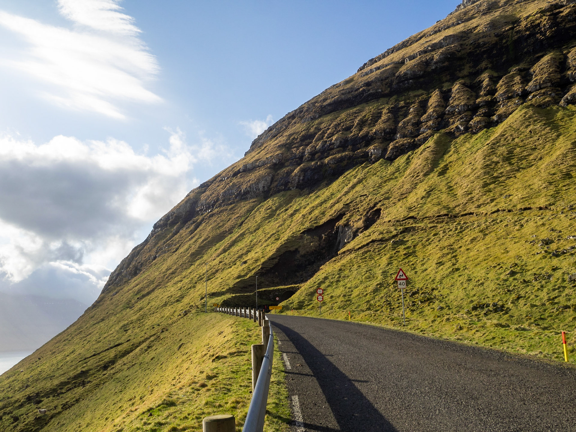 A tunnel cutting through the mountain slop in Kalsoy