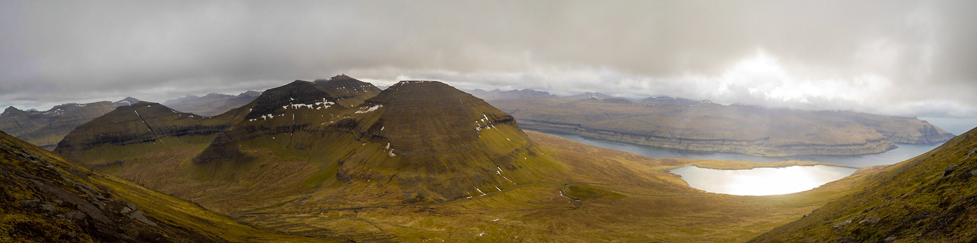 Hiking Slættaratindur looking at Vaðhorn, Blámansfjall and Húsafjall with lake Eidi, Sundini sound and Streymoy island in background