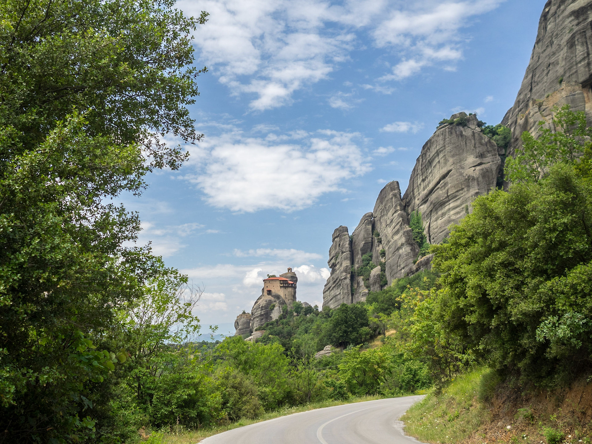 Meteora road below the rocks with Moni Agiou Nikolaou monastery in the far out