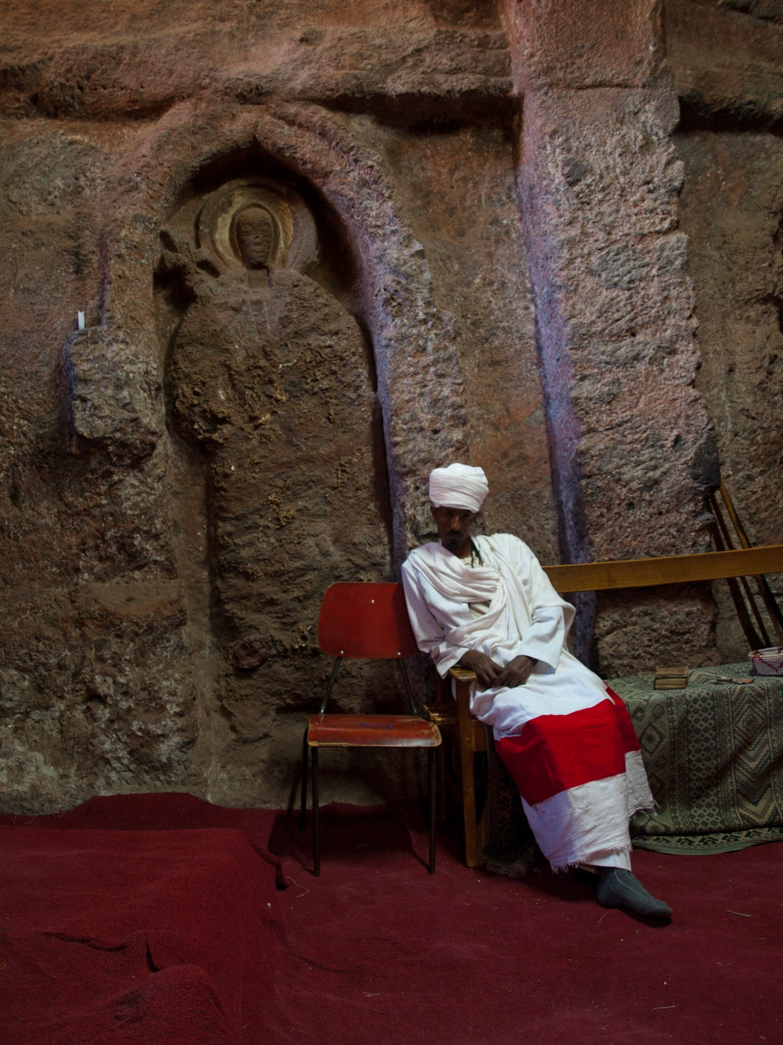 Priest inside the church of The Tomb of Christ, Lalibela