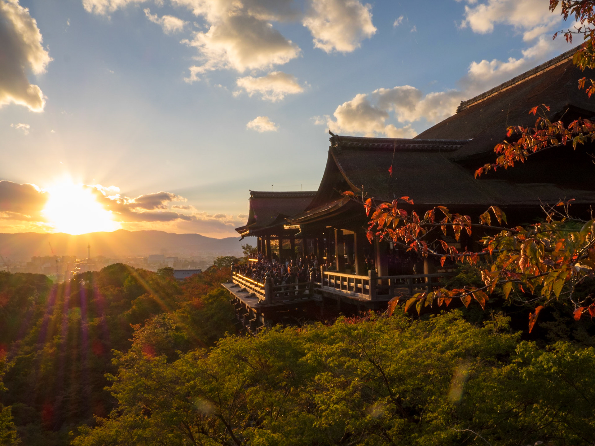 Kiyomizu-dera temple at the end of the day with the sun setting over Kyoto mountains in background