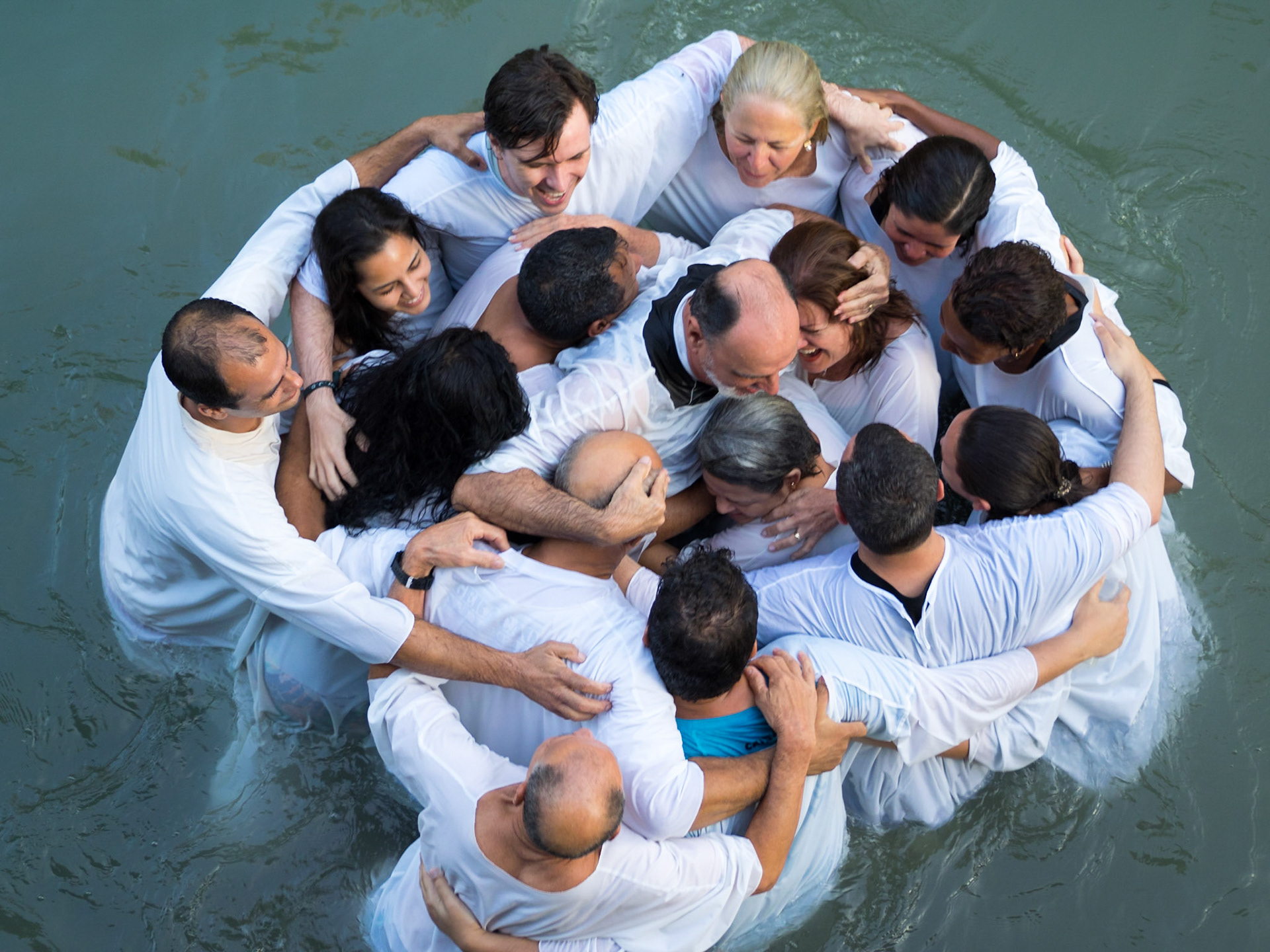 A priest in the middle of a Christian group in Yardenit baptismal site in Jordan river