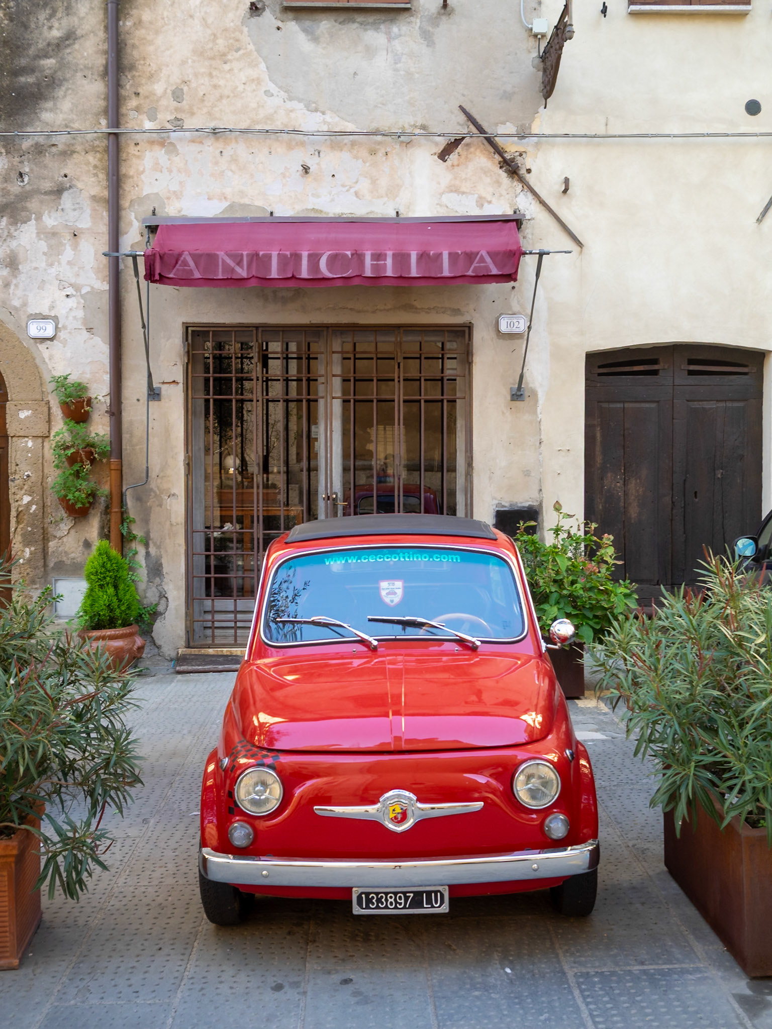 Red old Fiat 500 car in Pitigliano street
