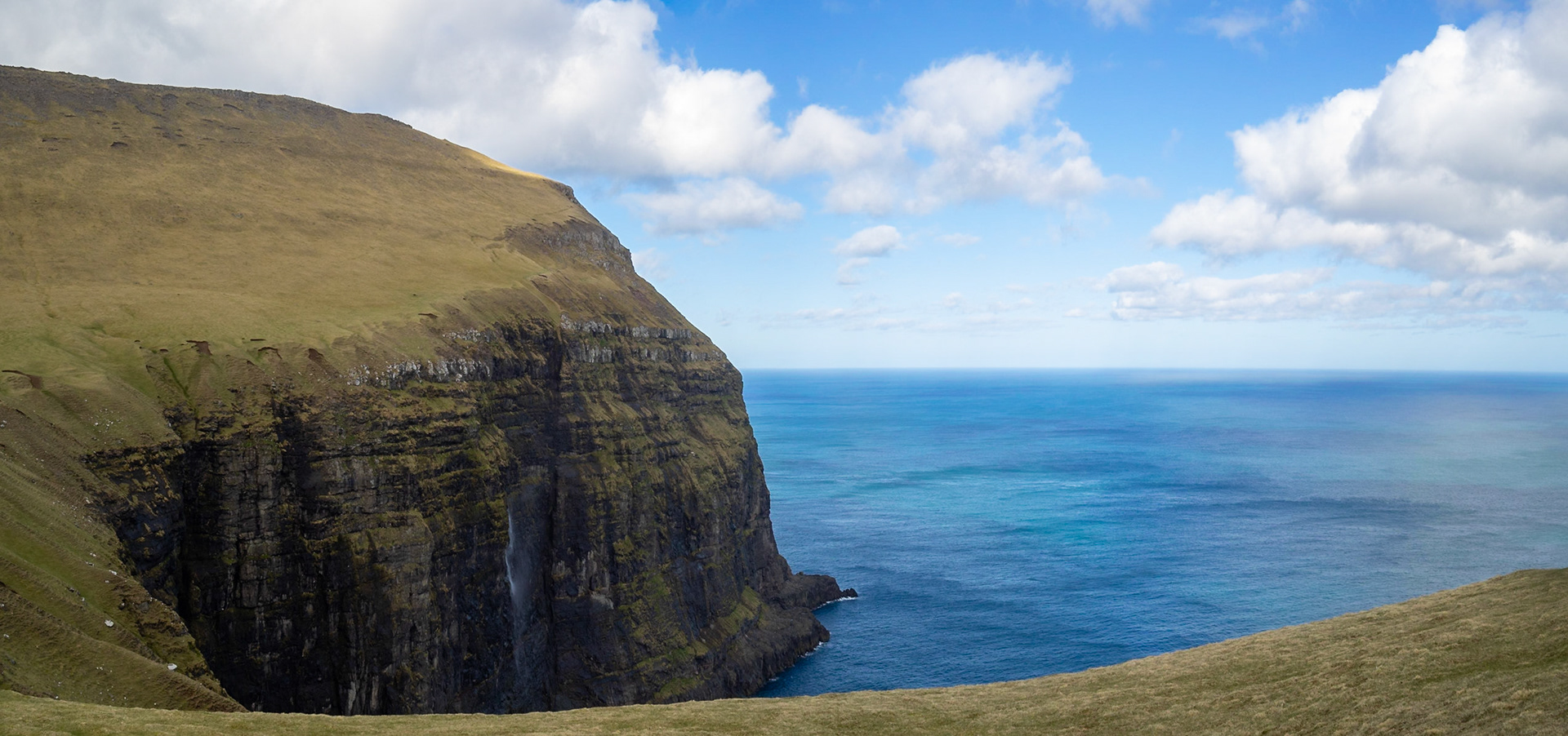 Waterfall from the cliffs over the sea from Fjallið mountain