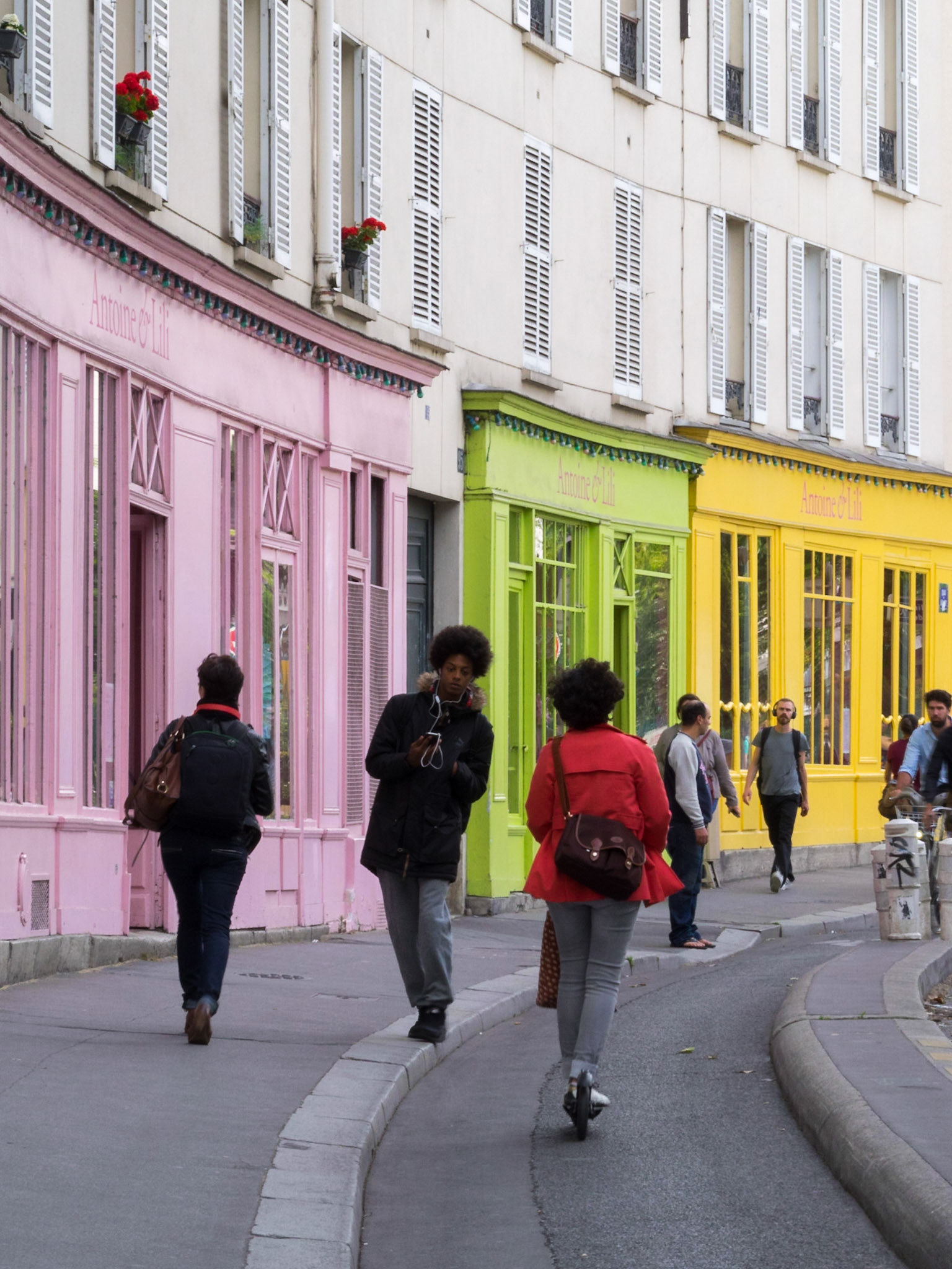 Parisian pedestrians by a colorful building