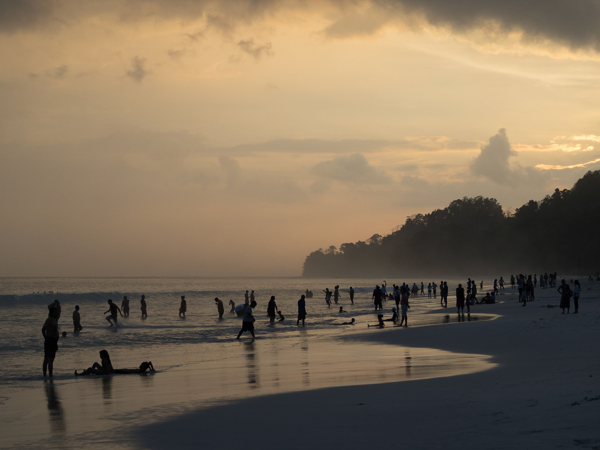 People silhouettes at sunset in Radhanagar beach, Havelock