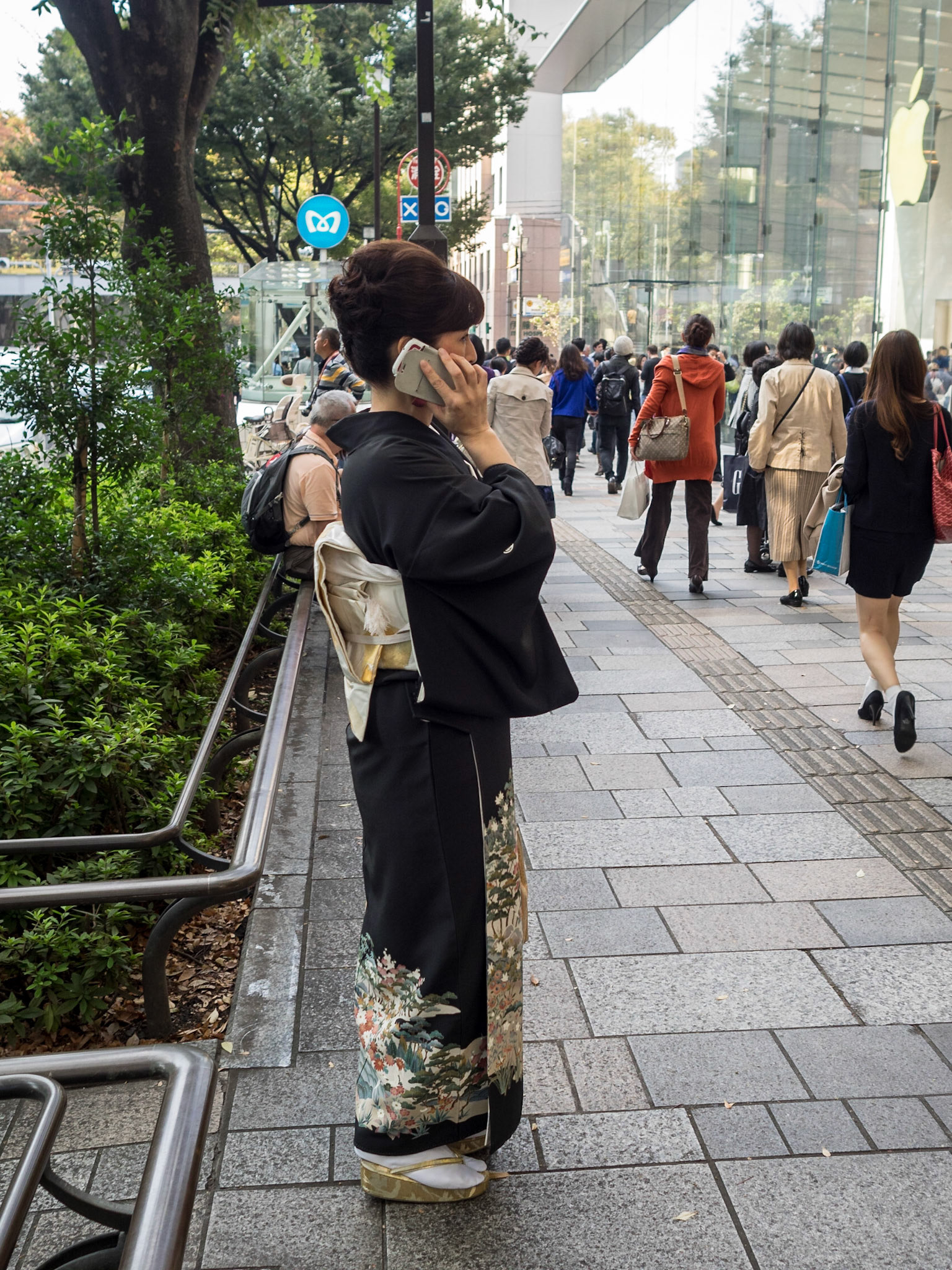 Woman in traditional japanese costume talking on the phone on the street