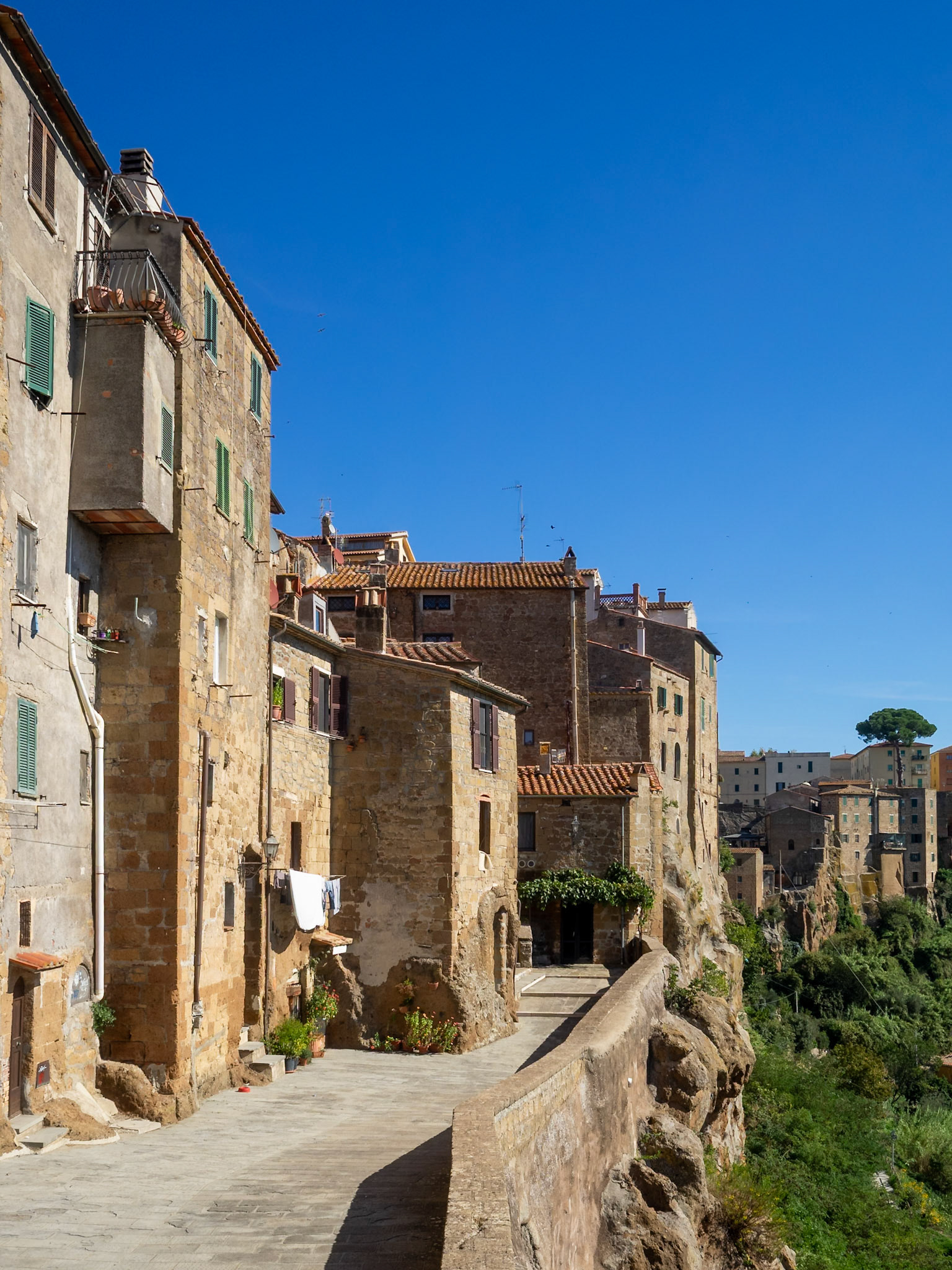 Pitigliano stone buildings atop the rock cliff