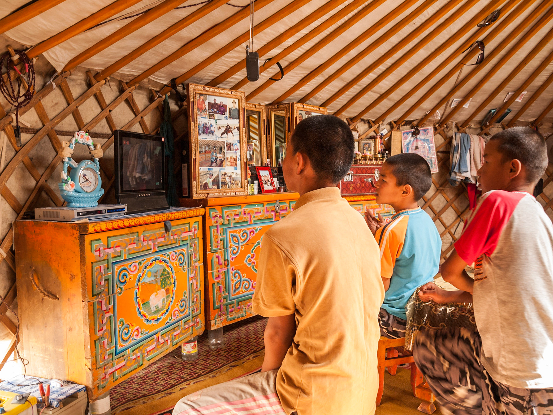 Mongolian boys watching Tv inside the ger