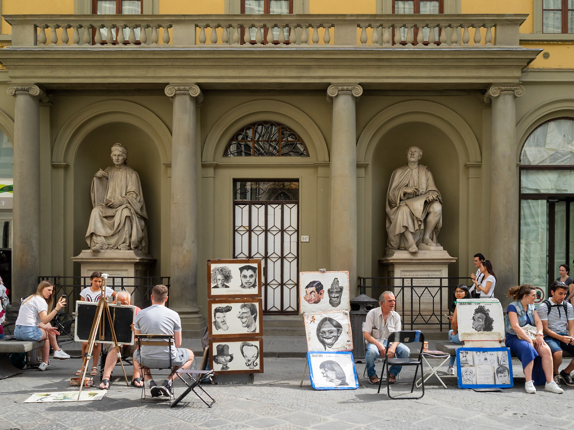 Street artists make cartoon portraits of tourists in Florence