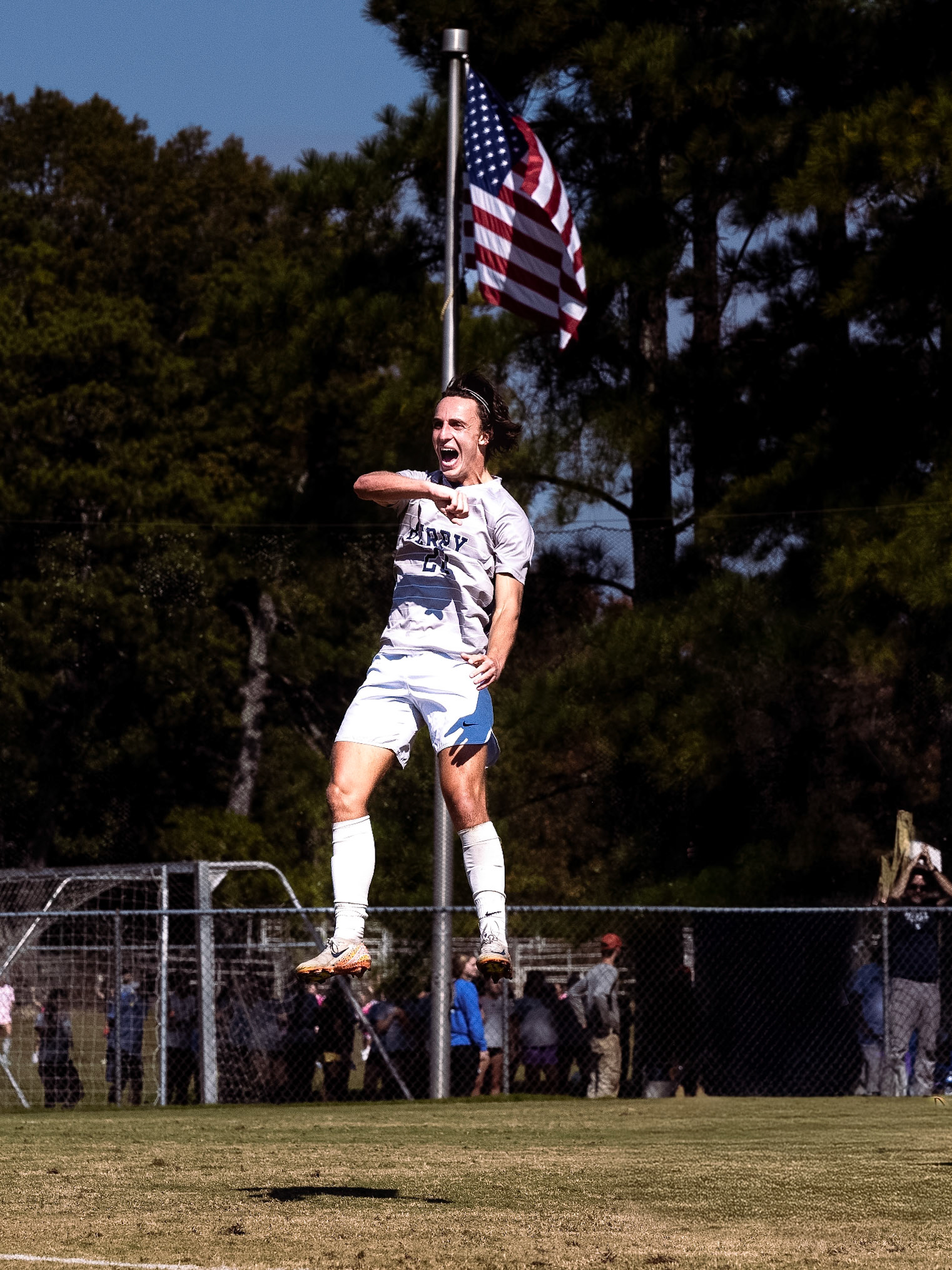 Berry College’s Tracy Moon celebrates a goal against Oglethorpe with the American flag in the foreground.
