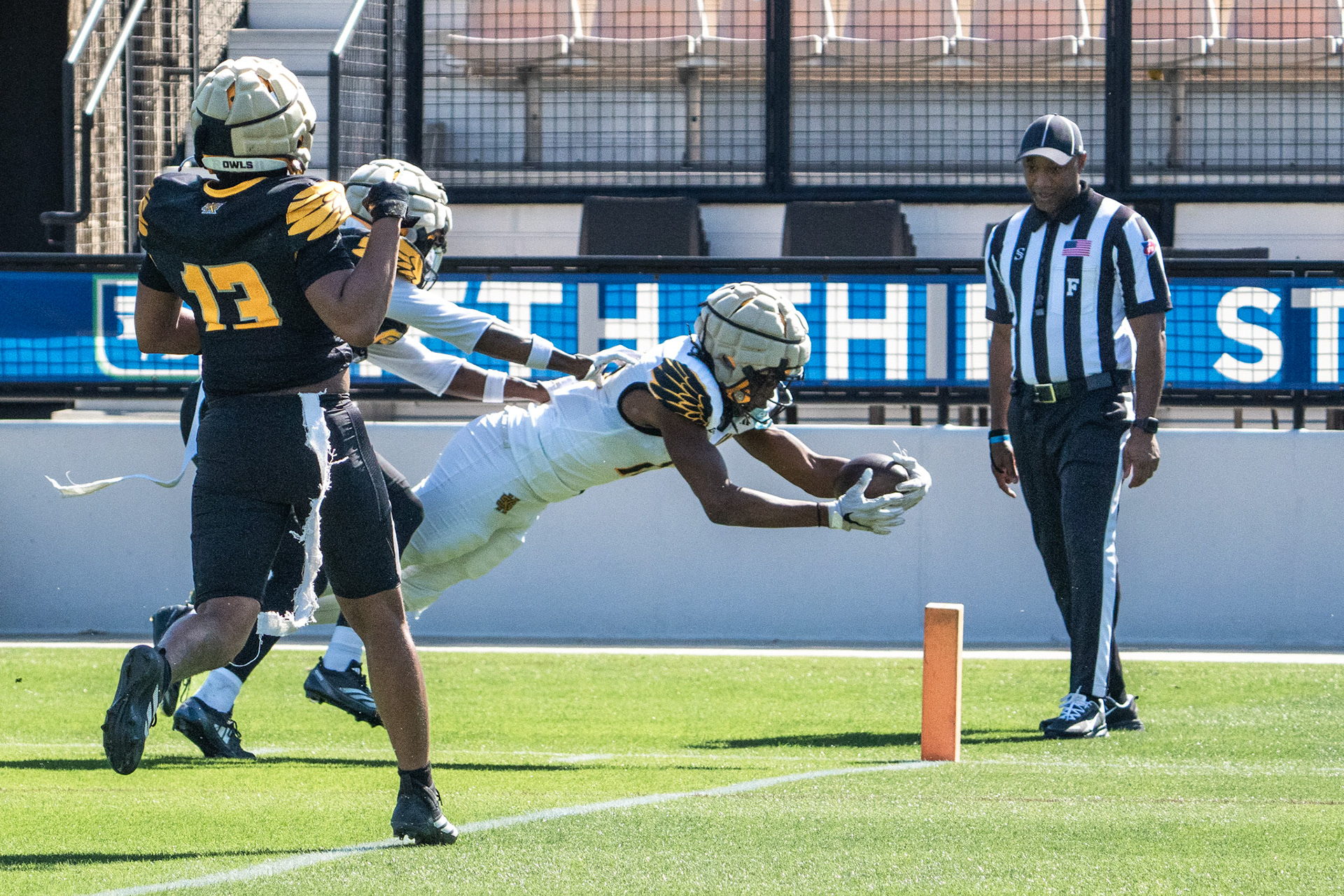 A Kennesaw State wide receiver stretches for the end zone during the Owls’ spring game.