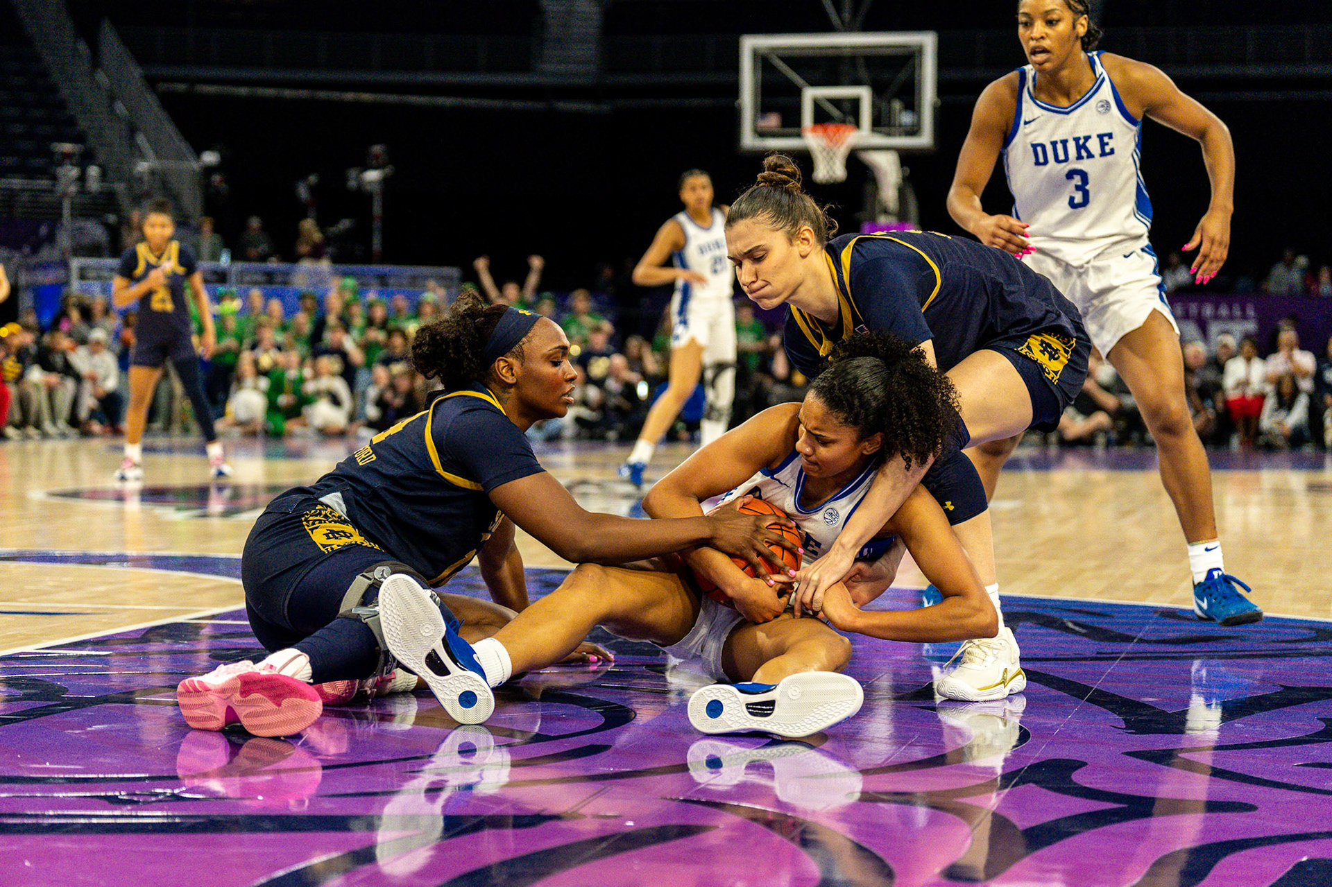 Notre Dame defenders swarm a Duke player for the loose ball.