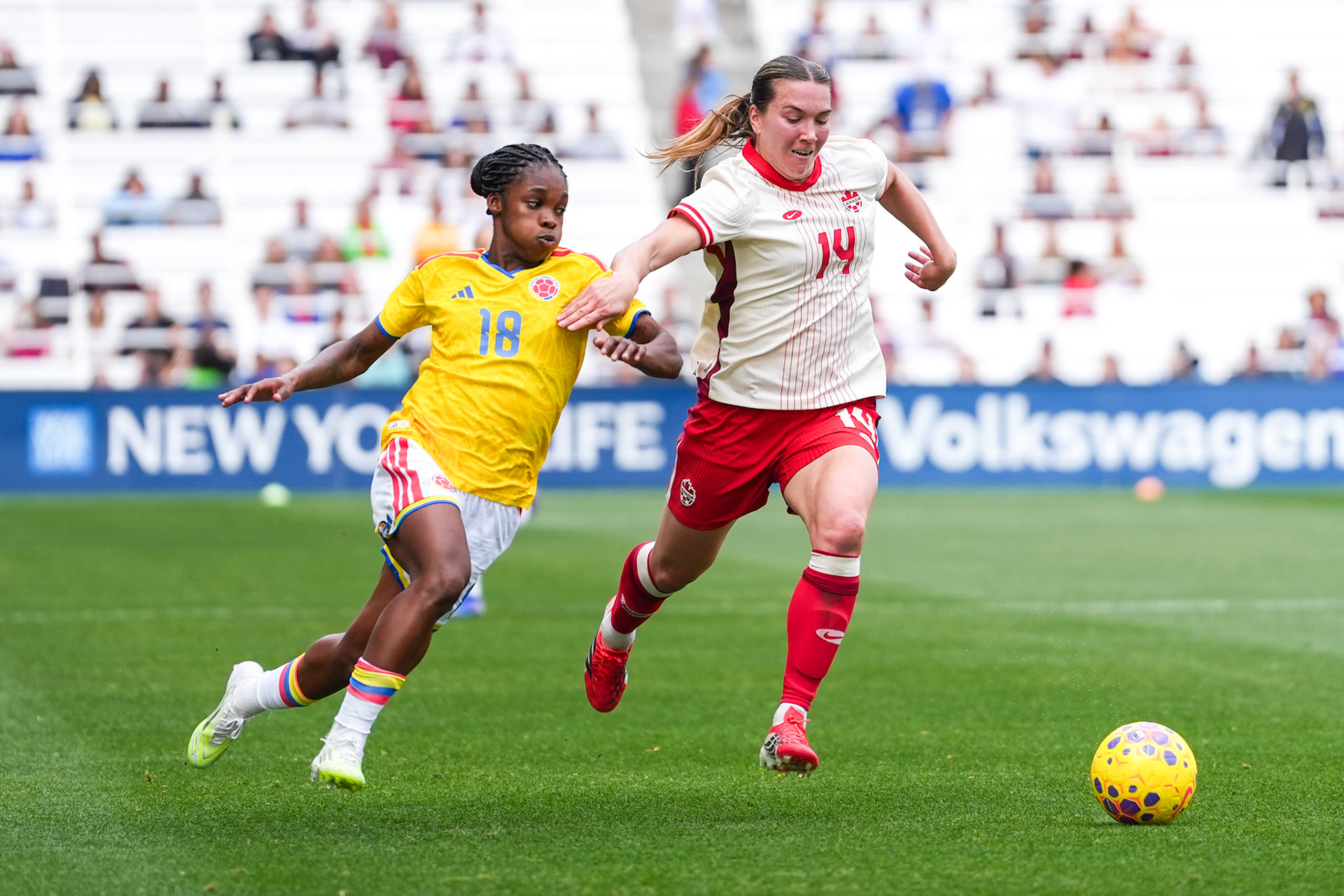 Canada defender Vanessa Gilles (14) pressures Colombia forward Linda Caicedo (18) during an international match.