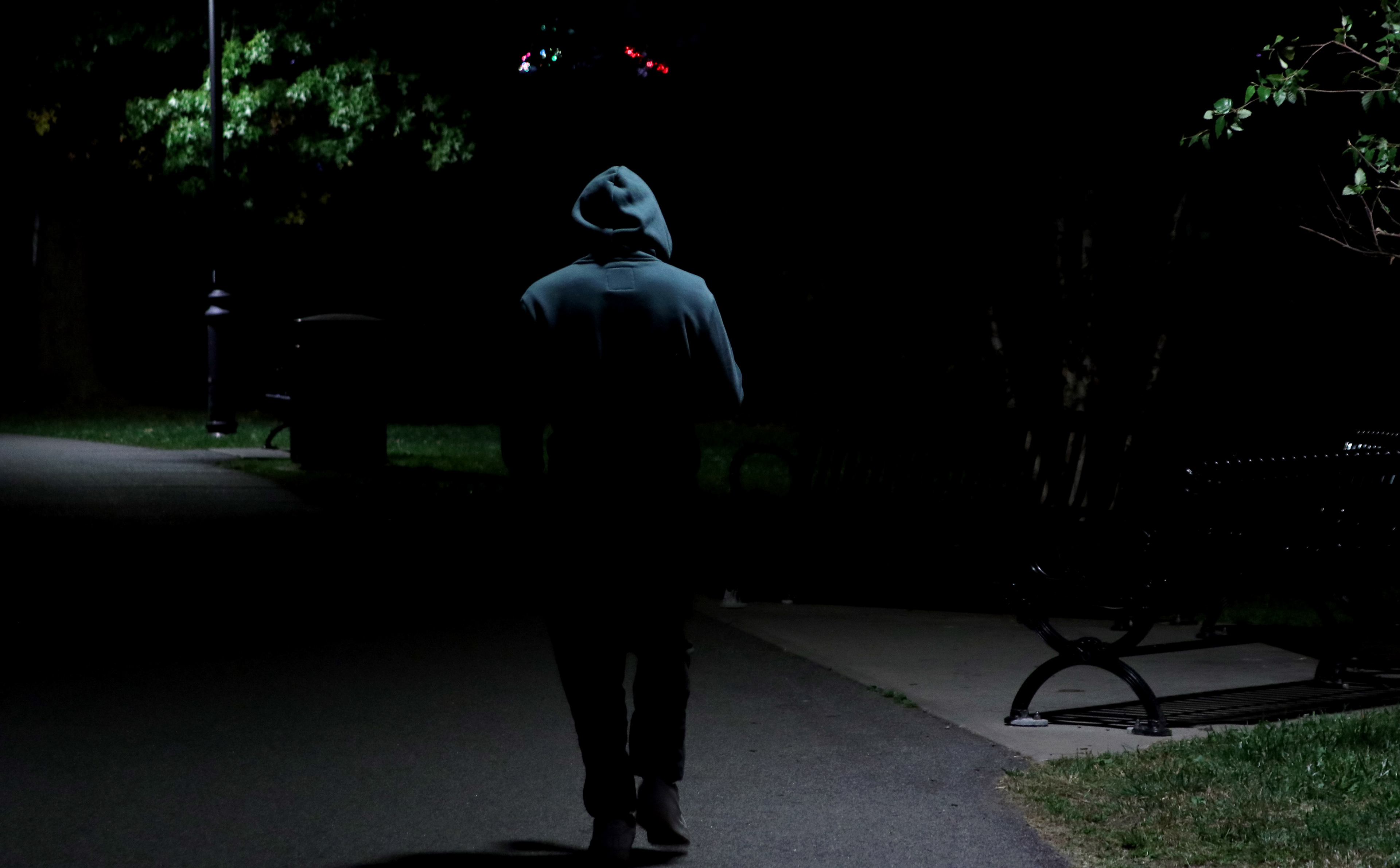 NORTH BERGEN, NJ, 10-07-2024 SILHOUETTE OF A PERSON: A person walks in 80th Street Park in North Bergen, New Jersey, on October 7. Their silhouete is framed by the lights as day turns into night. The image captures the peacefulness of an evening in a quiet place.