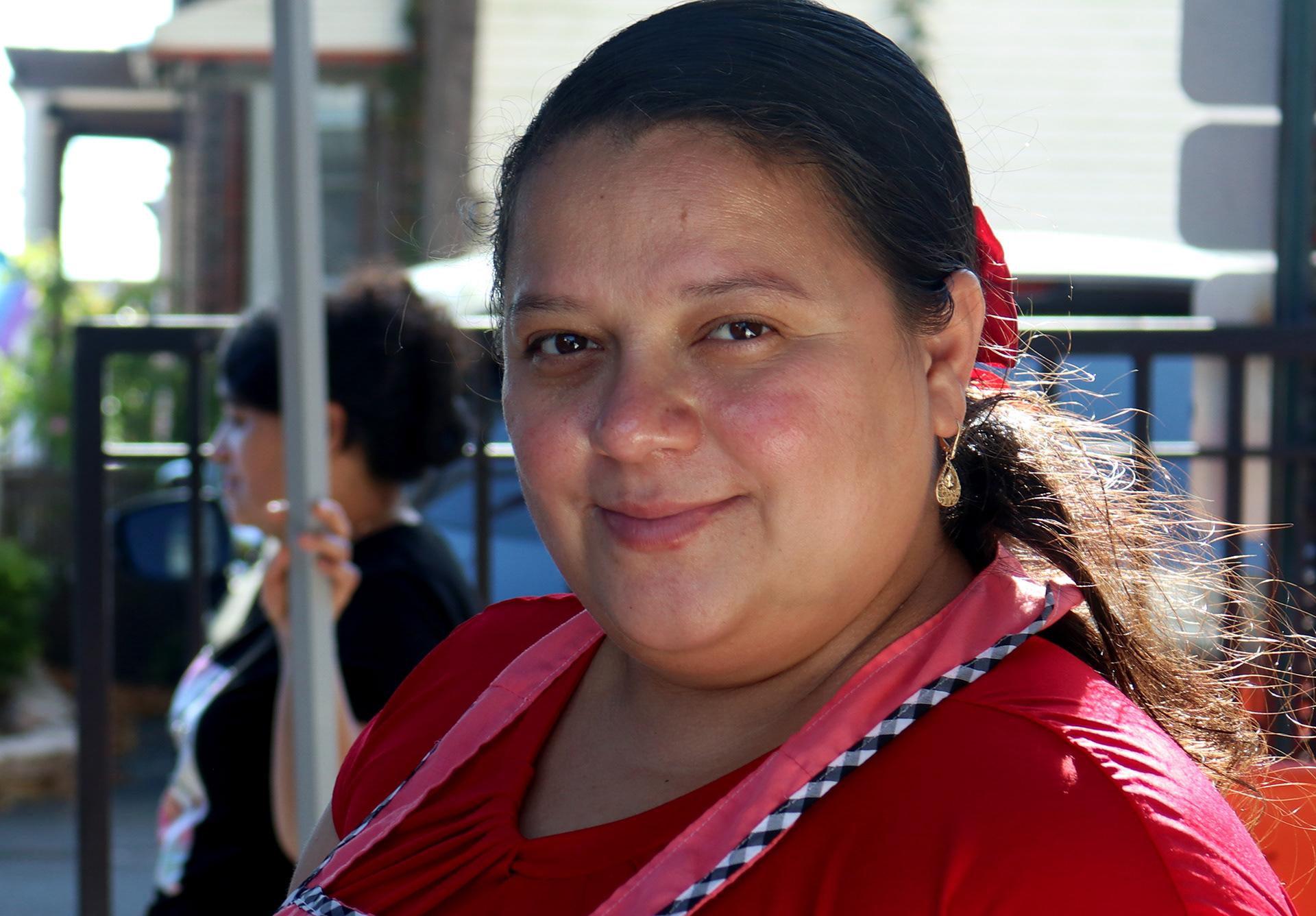 UNION CITY, NJ, 10-07-2024 TIGHT PORTRAIT OF A WOMAN: A woman smiles as she sells pupusas at a flea market by SS Joseph & Michael Roman Catholic Church in Union City, New Jersey, on October 7. This photograph captures the her conection and humility as she interact with customers.
