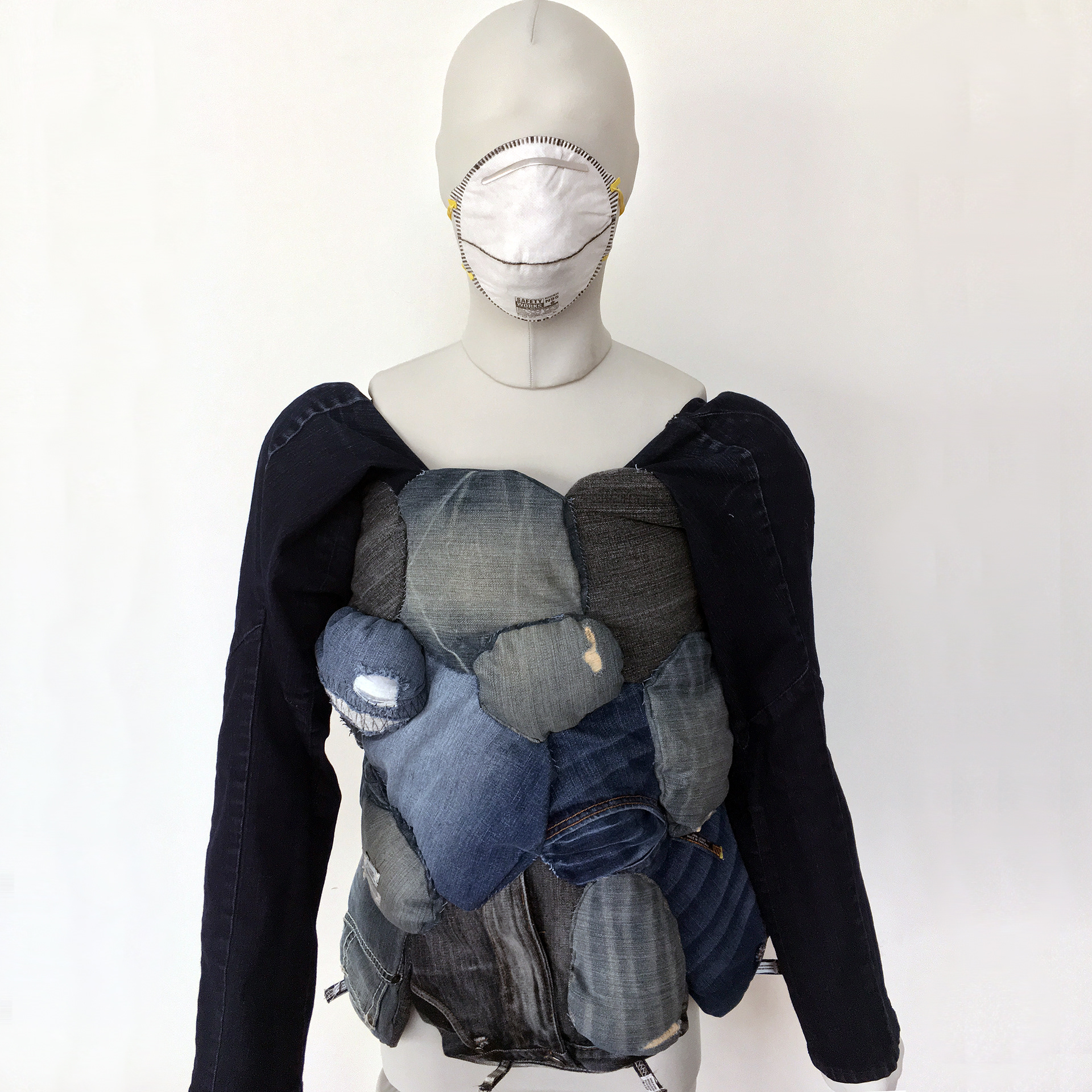 The Complexities of Denim (2018) thrift store denim, thread, ventilator mask // Commission for the University of Iowa Museum of Art and Hello Flyover.  After researching the human & environmental costs of denim, I created a wearable using a material palette from the thrift store of intentional factory rips & surface wear sourced from mainly China & Southeast Asia. The design is of a shared burden. Because on any given day, it is estimated that half the world’s population is wearing jeans. What is the responsibility of the designer & consumer in protecting the planet? The piece is informed by work by Lewis Wickes Hine in the UIMA collection specifically Doffer Girl in New England Mill (1908)